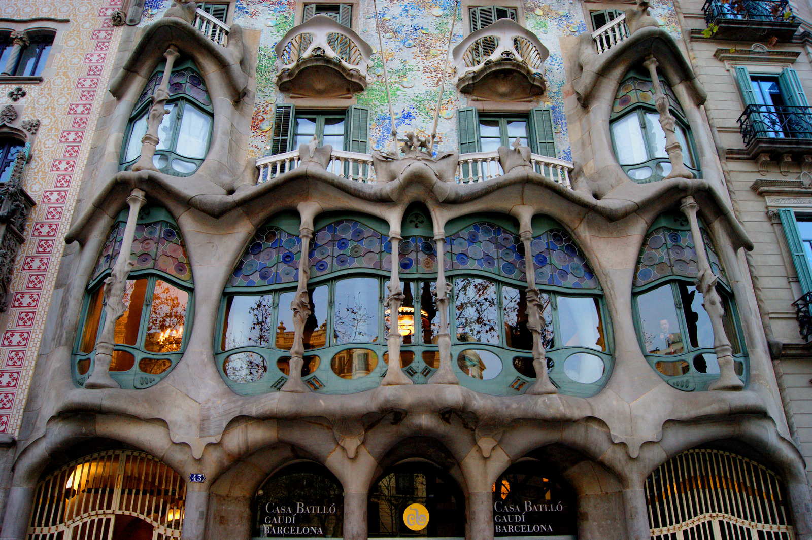 Casa Batlló in Barcelona with vibrant mosaic facade, curved windows, and dragon-scale rooftop designed by Antoni Gaudí.