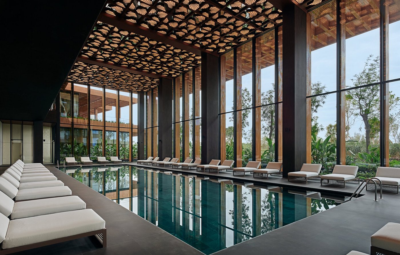 Luxurious indoor pool with high decorative ceilings, and plush pool loungers surrounded by massive floor to ceiling windows to capture the view - Maxx Royal Bodrum, Turkey