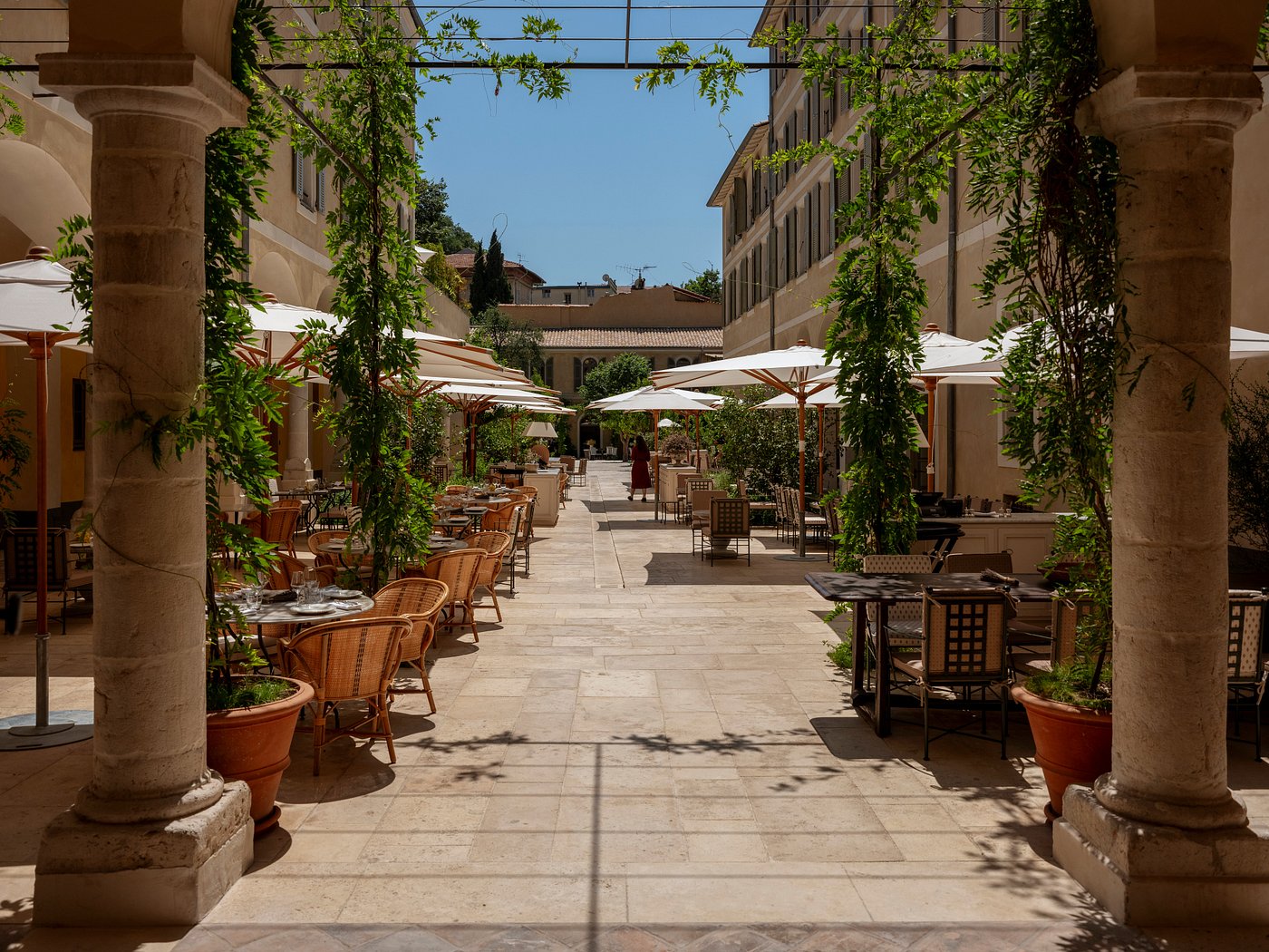 Columns covered in vines mark the entrance to an elegant, outdoor restaurant at the Hotel du Couvent, Nice, France