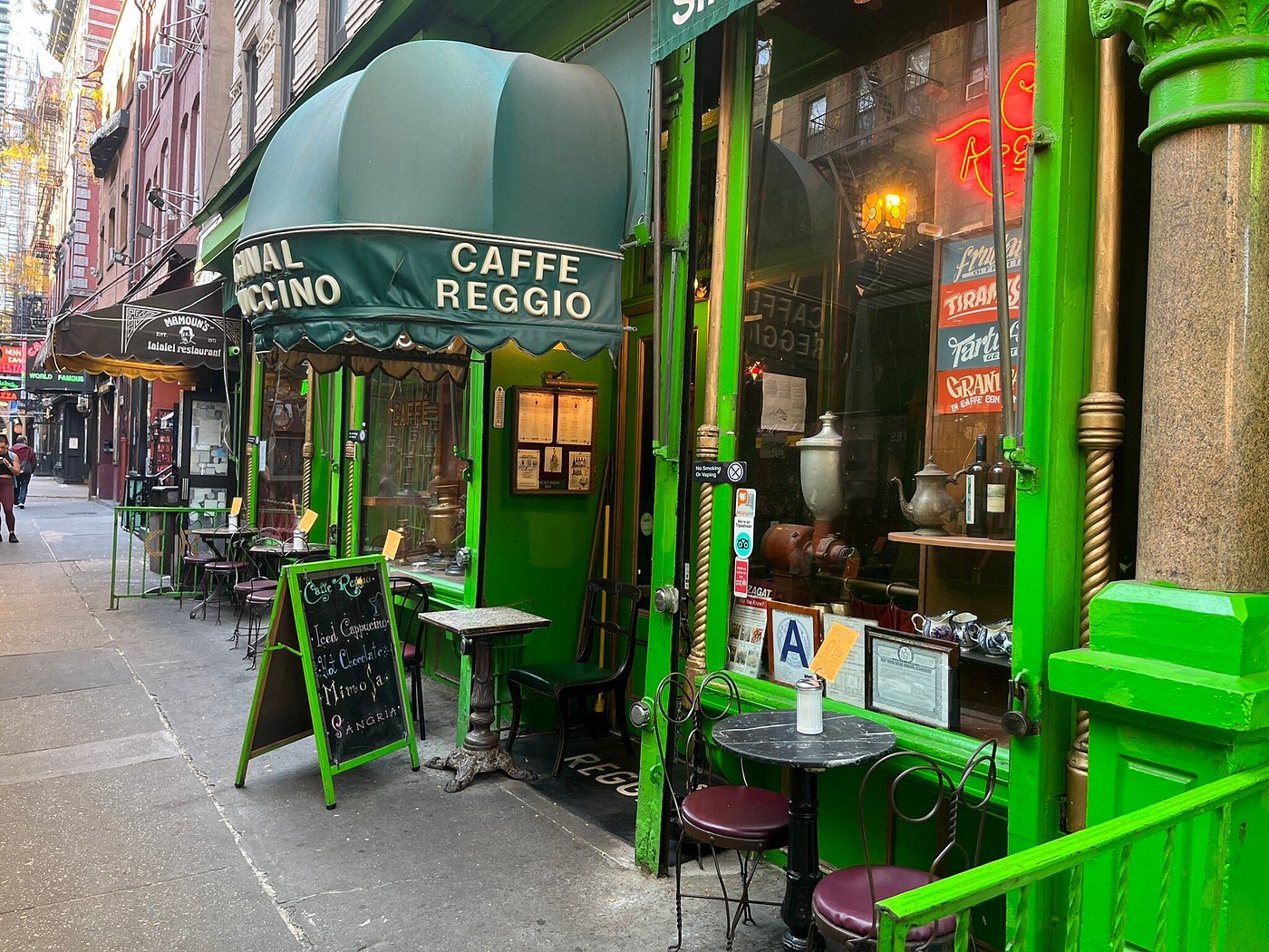 Greenwich Village café with vintage espresso machine and Renaissance-style art.