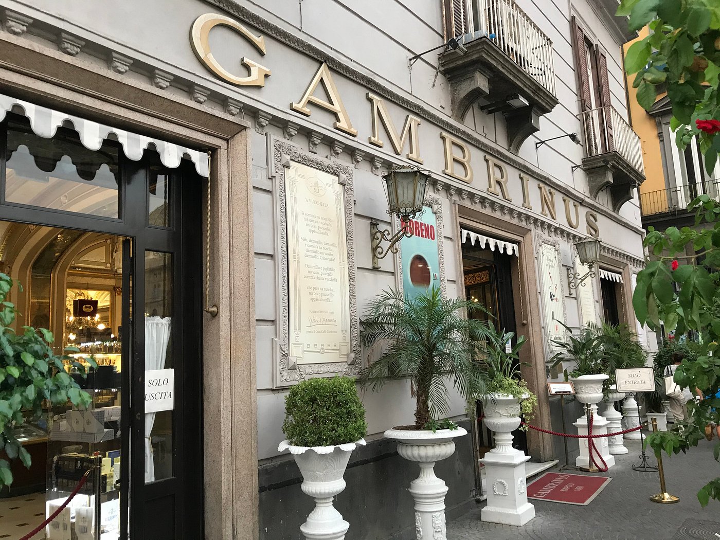 Belle Époque café in Naples with marble, stucco, and historic paintings.