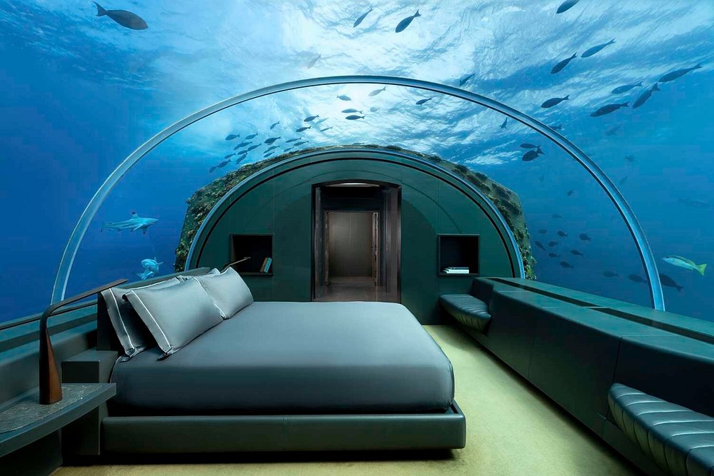 Underwater luxury suite at The Muraka, Conrad Maldives, with panoramic glass walls offering views of tropical fish and marine life