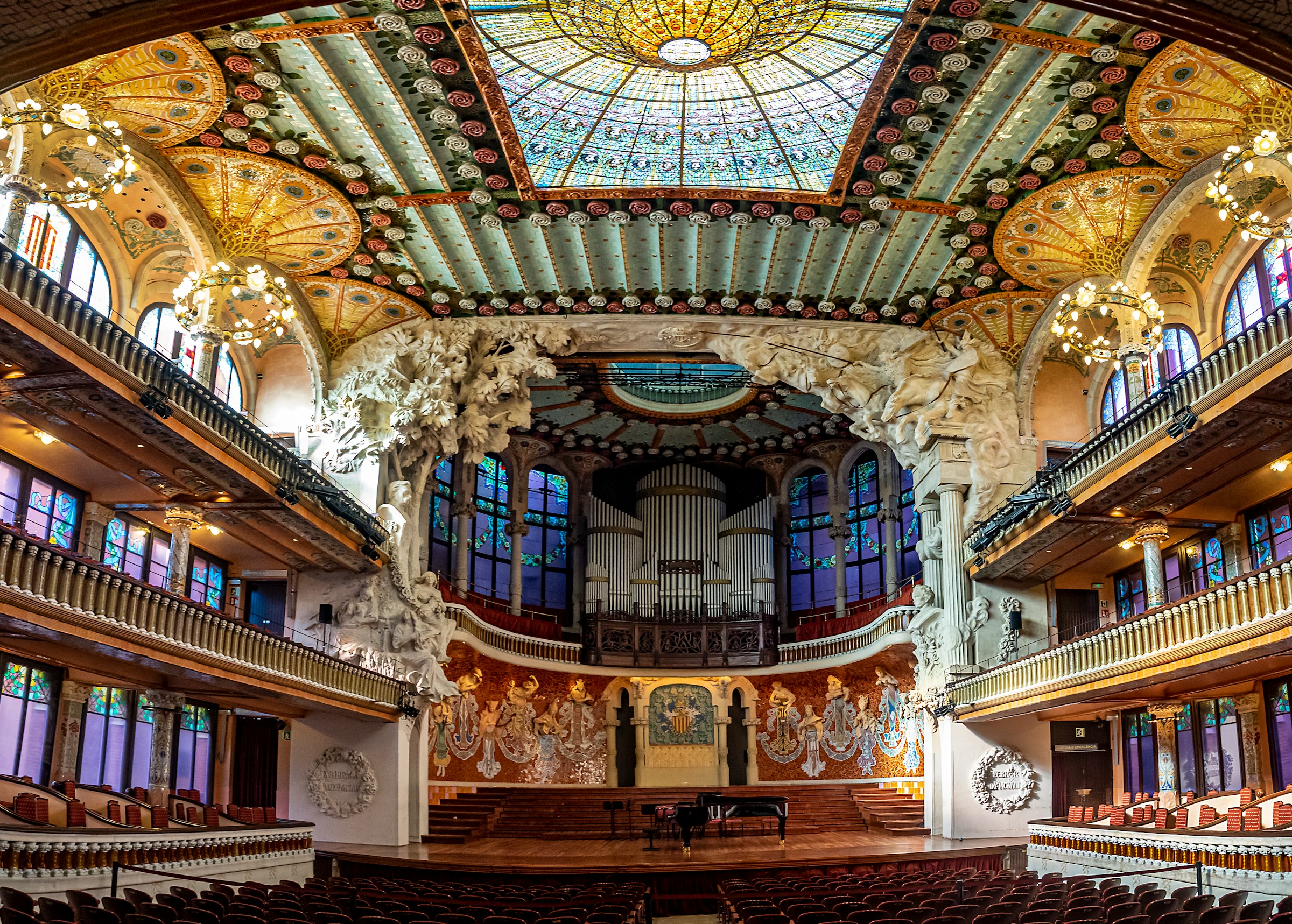 Palau de la Música Catalana concert hall in Barcelona with colorful stained-glass dome and ornate mosaic details.