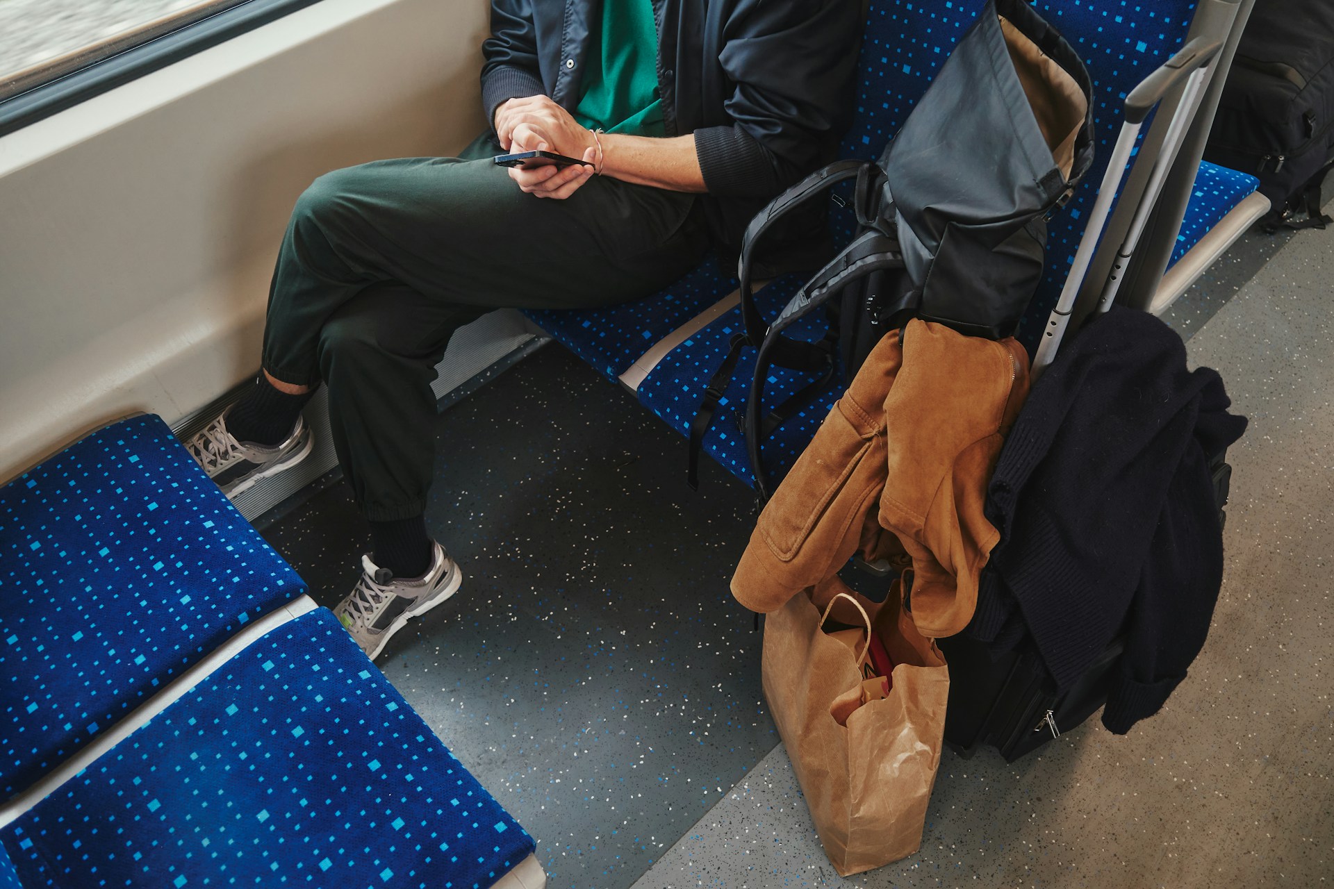 Train passenger takes up two seats with luggage and other personal belongings. 