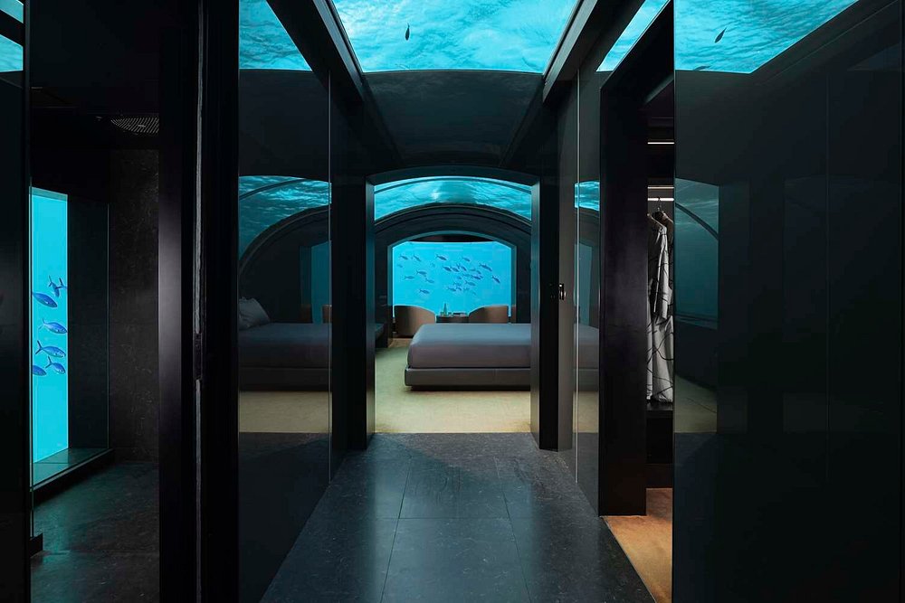 Luxury underwater hotel suite at The Muraka, Conrad Maldives, with panoramic ocean views of tropical marine life.