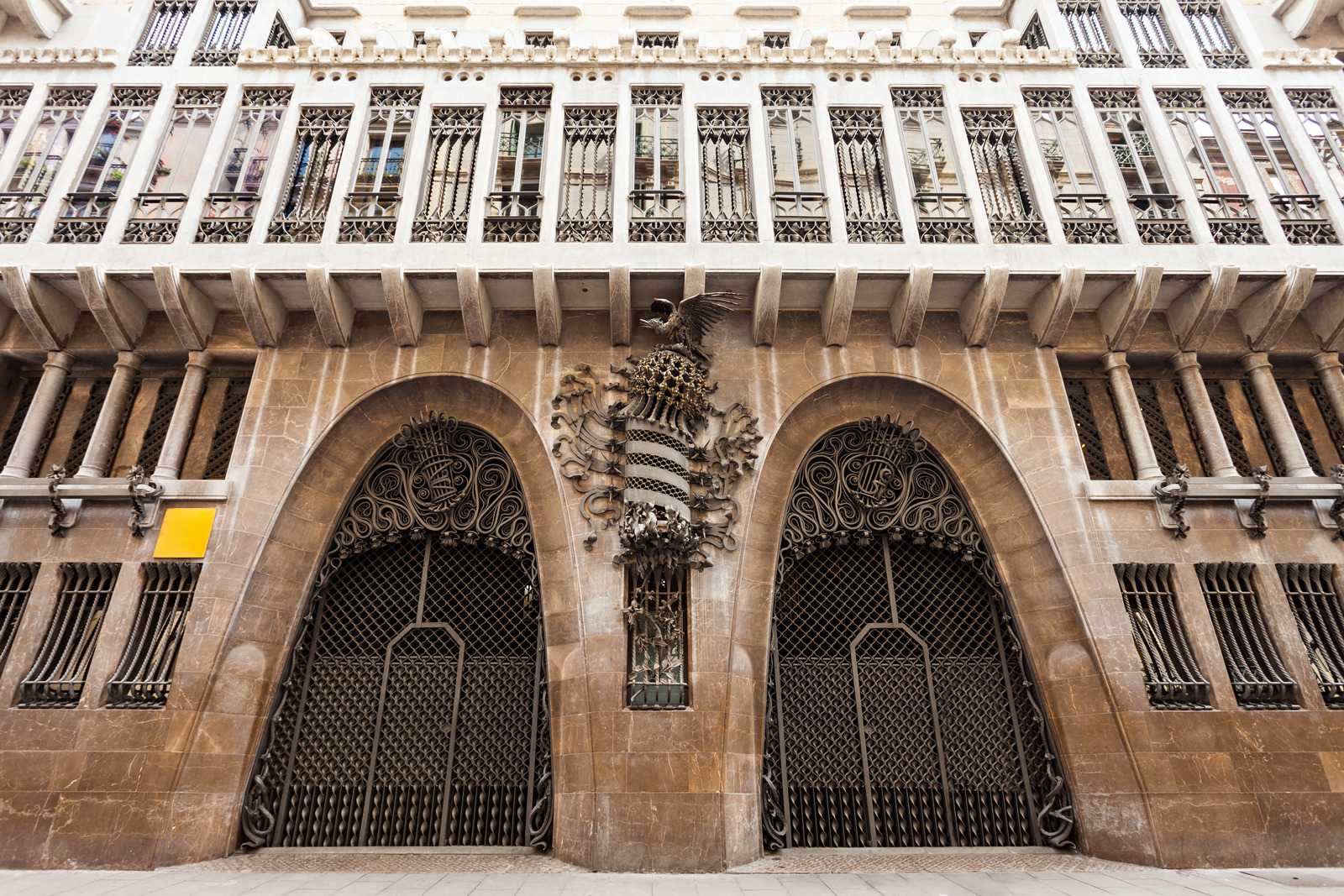 Palau Güell in Barcelona with ornate ironwork, Gothic-inspired architecture, and colorful Gaudí-designed rooftop chimneys.