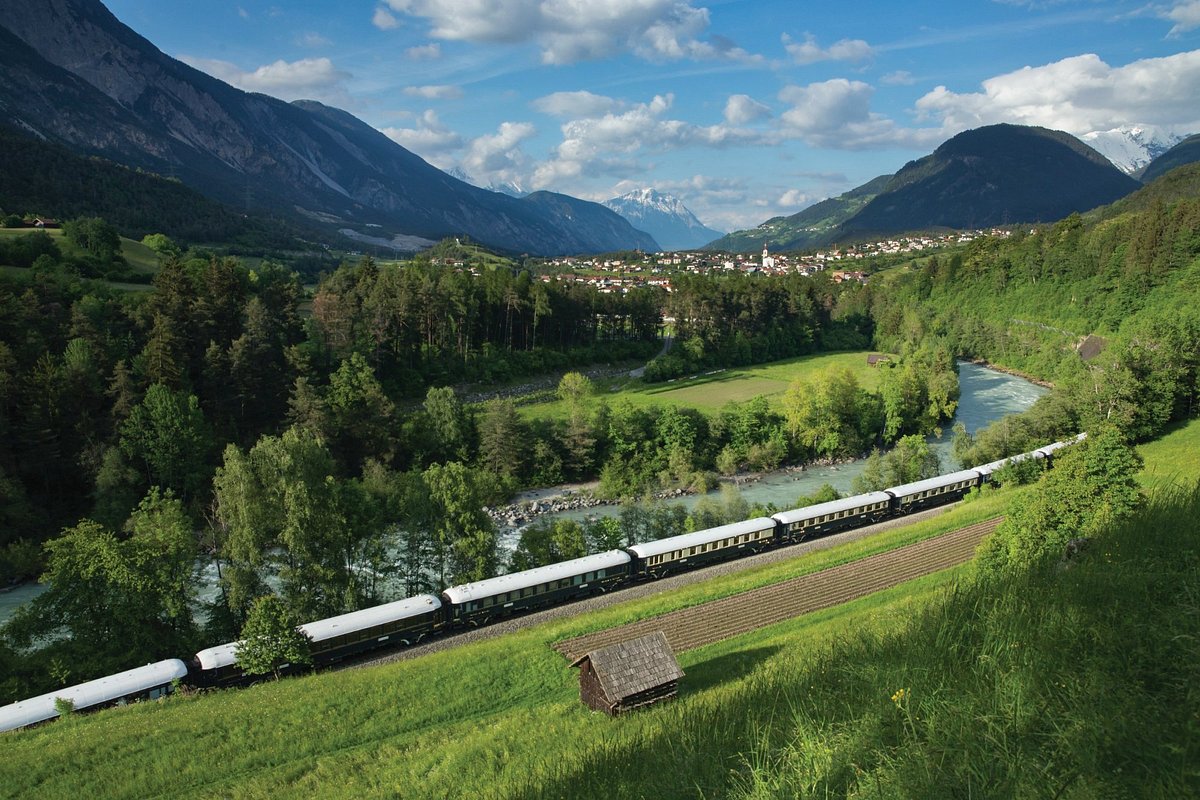 Venice Simplon-Orient-Express luxury train traveling through the Austrian Alps countryside