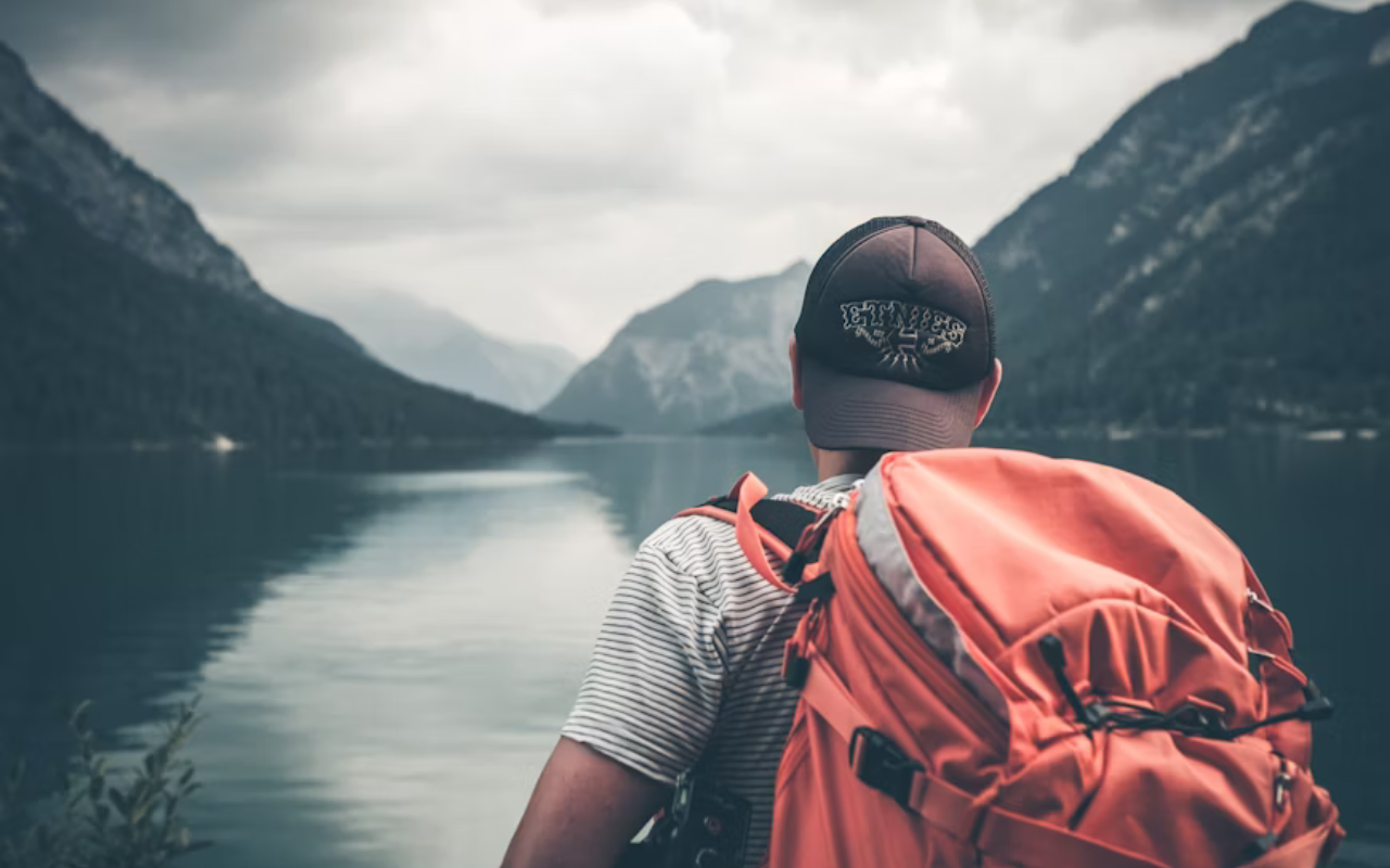 Traveler with backpack overlooking a mountain lake in the US that looks like Europe