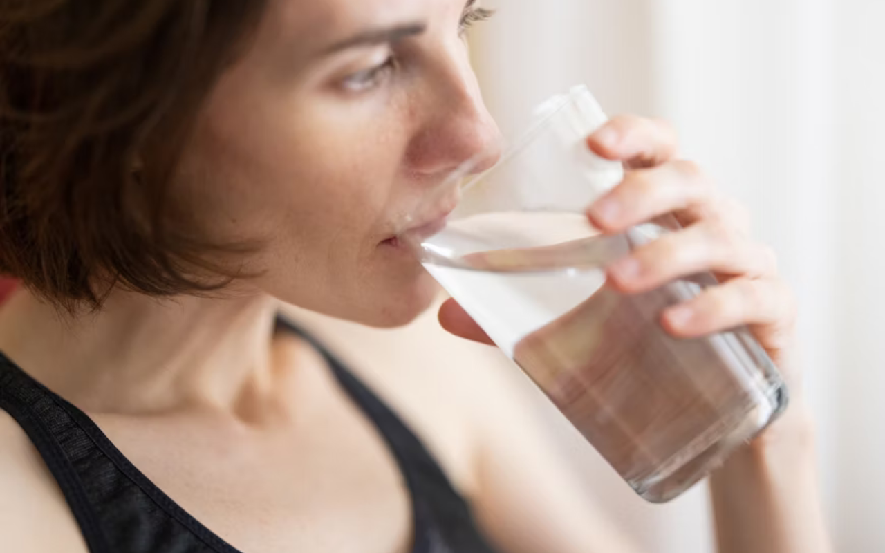 woman drinking water to stay healthy while on vacation