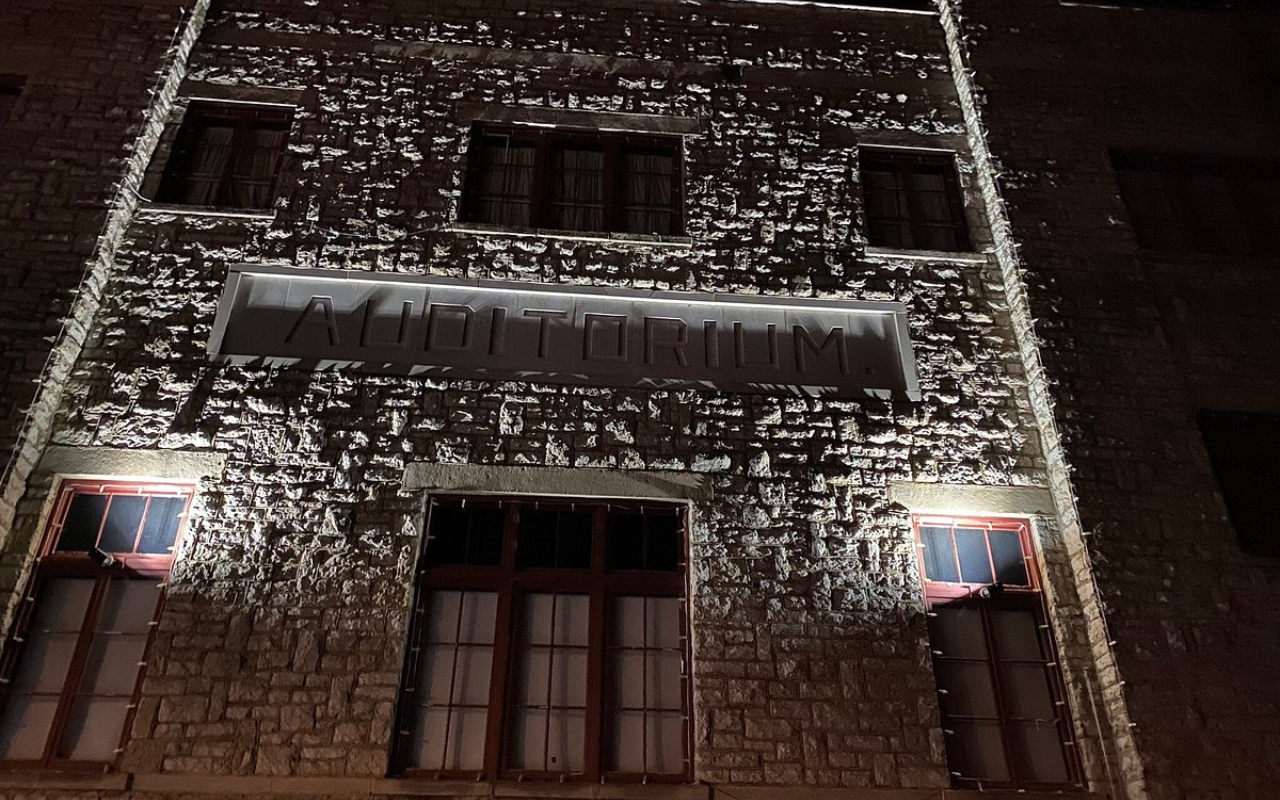 Historic stone auditorium in Eureka Springs, Arkansas, lit up at night for Halloween, showcasing the town’s haunted hotels and spooky seasonal charm.