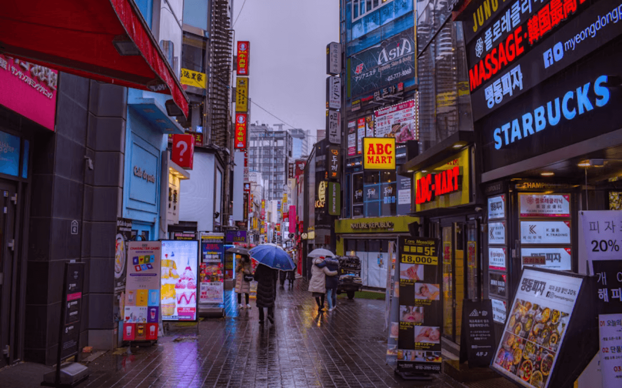 eople visit Myeongdong shopping district in Seoul by night.