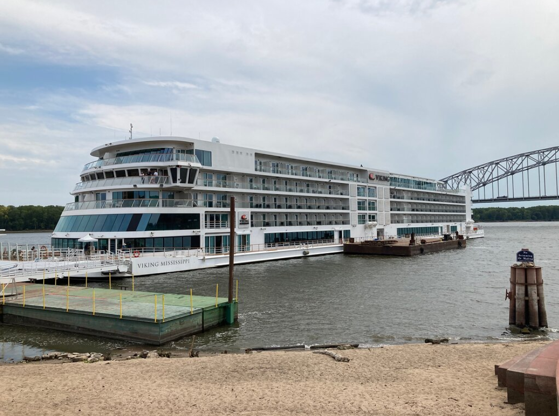 Large river cruise ship docked on the Mississippi River, showing the size and design differences of American vs. European river cruises.