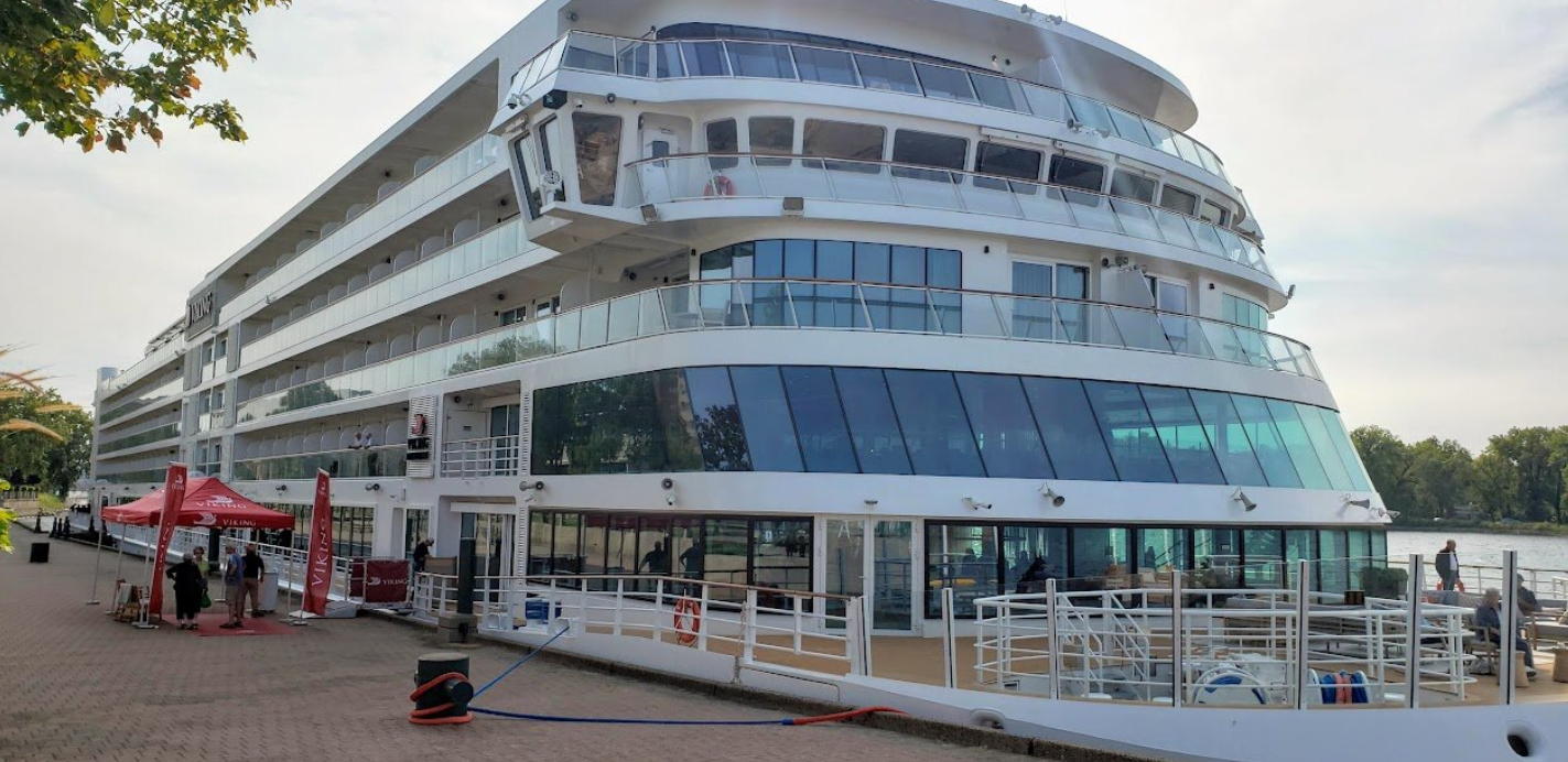Modern American river cruise ship docked, highlighting onboard amenities and cultural experiences.