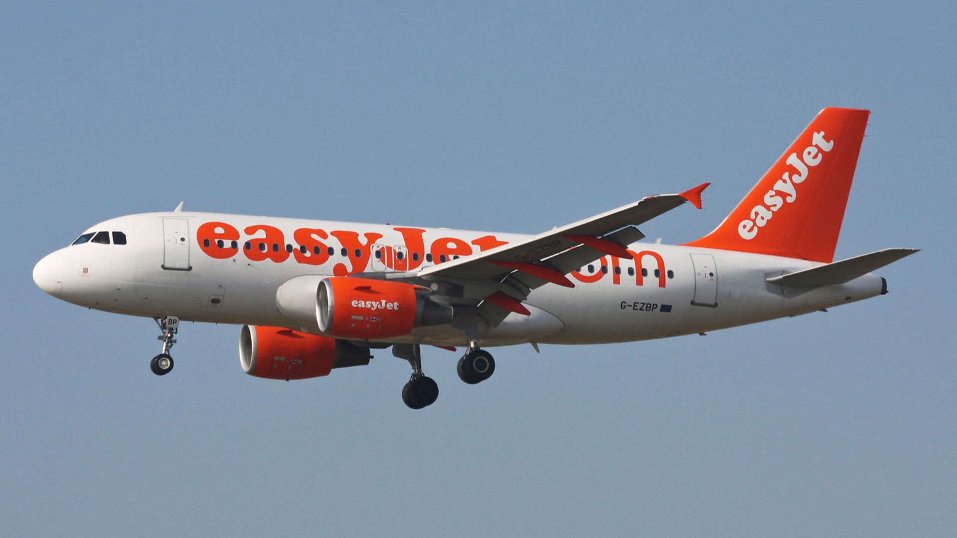 EasyJet plane in flight, representing the budget airline often criticized for unfriendly cabin crews and poor passenger service.