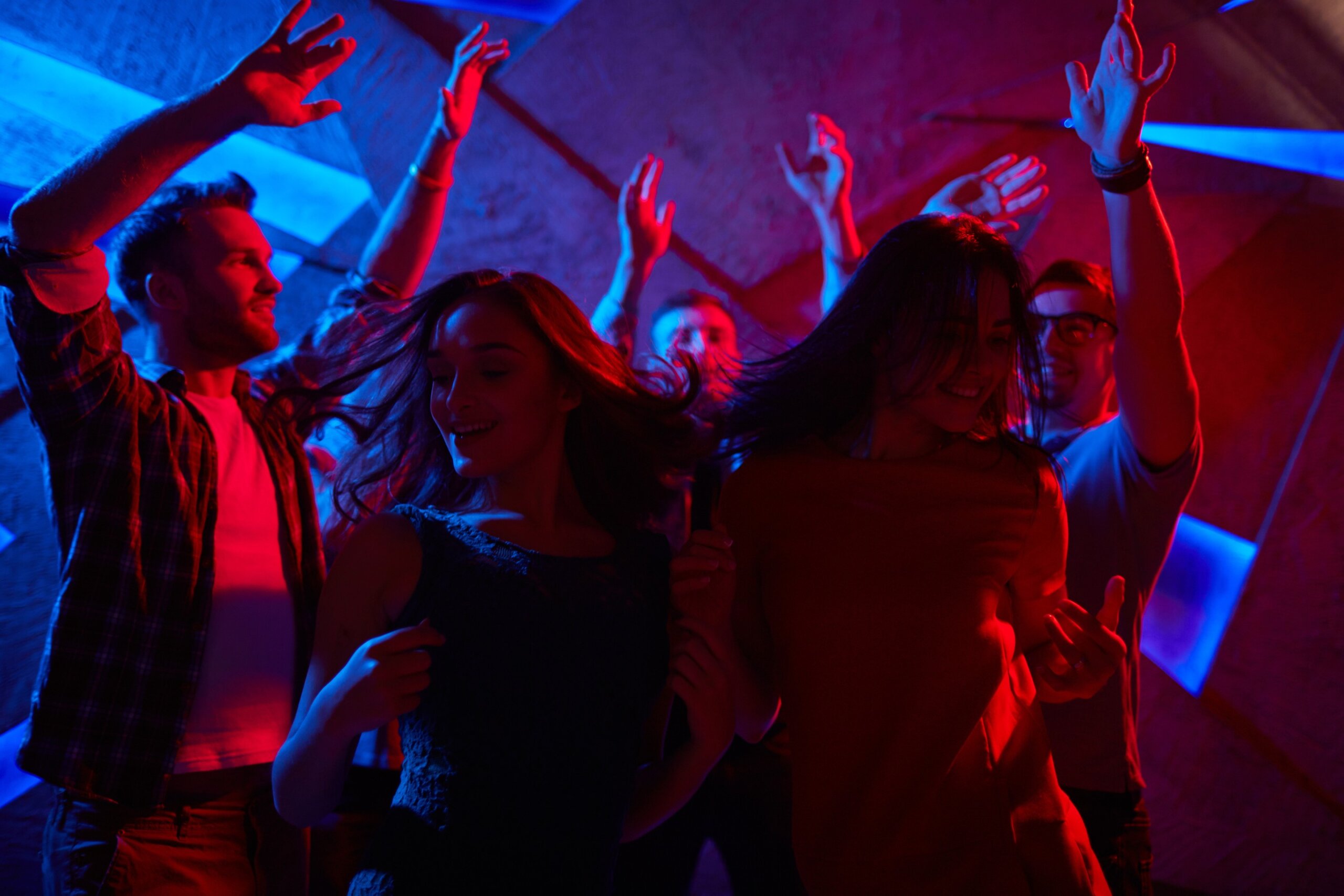 Group of young adults dancing at a nightclub on vacation.