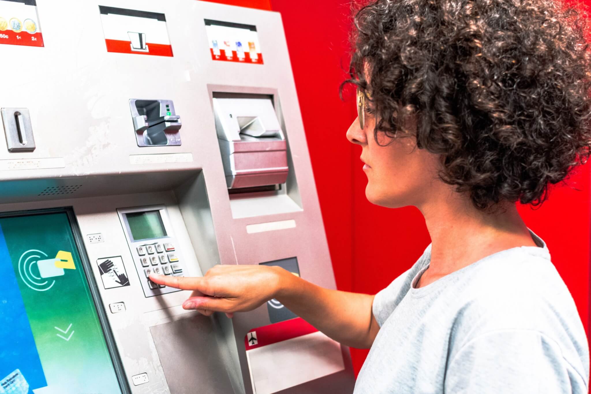Young woman using atm in a foreign country while traveling