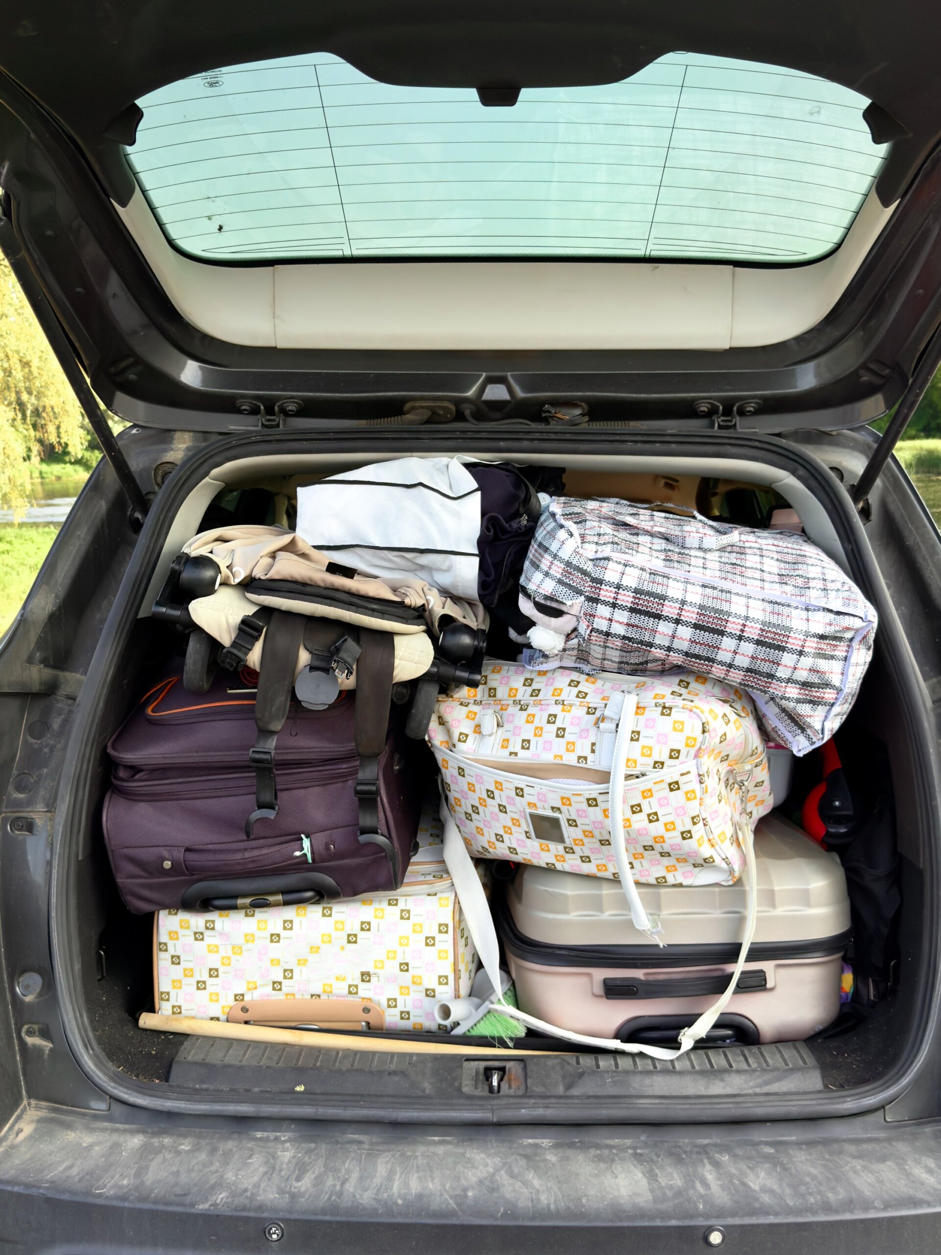 Luggage jam-packed into the trunk of a car. Overpacking concept image