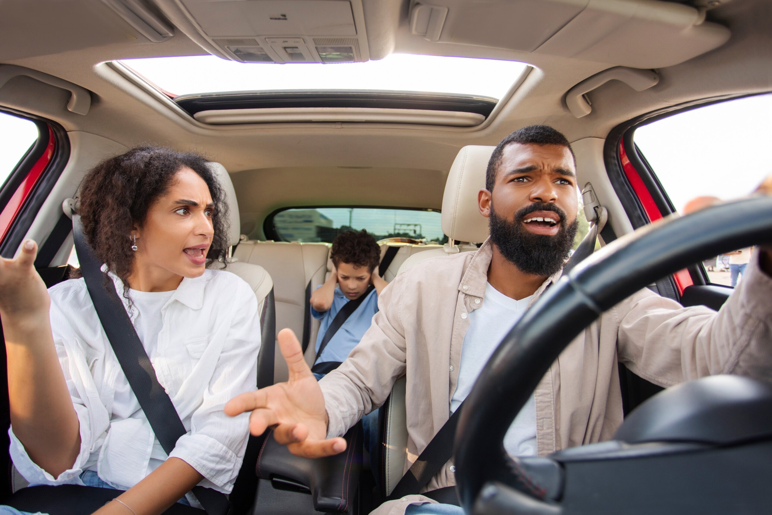 Latin parents arguing while driving car, kid boy feeling sad upset and covering ears with hands while mom and dad having conflict during car trip