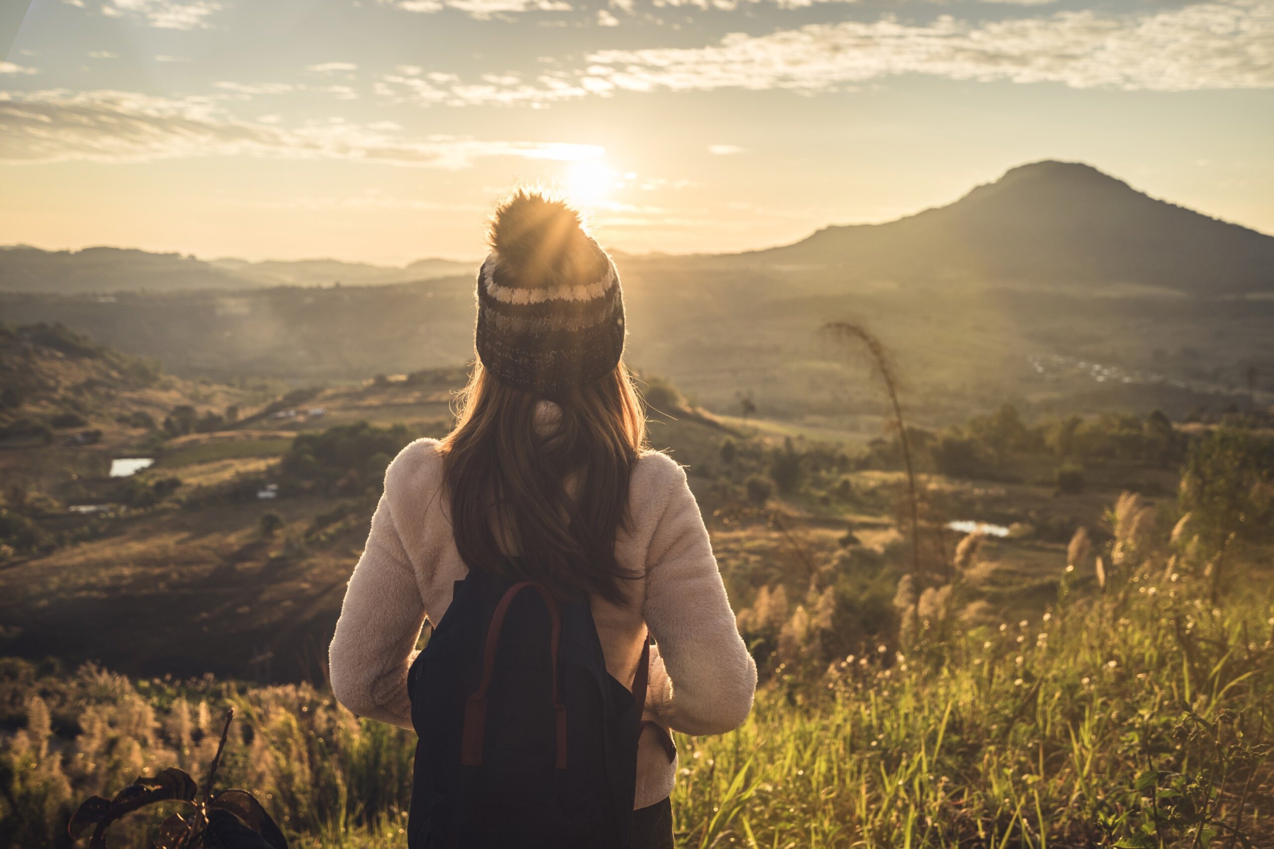 Young woman traveler looking at sunrise. Solo Traveler not fit for taking group tours