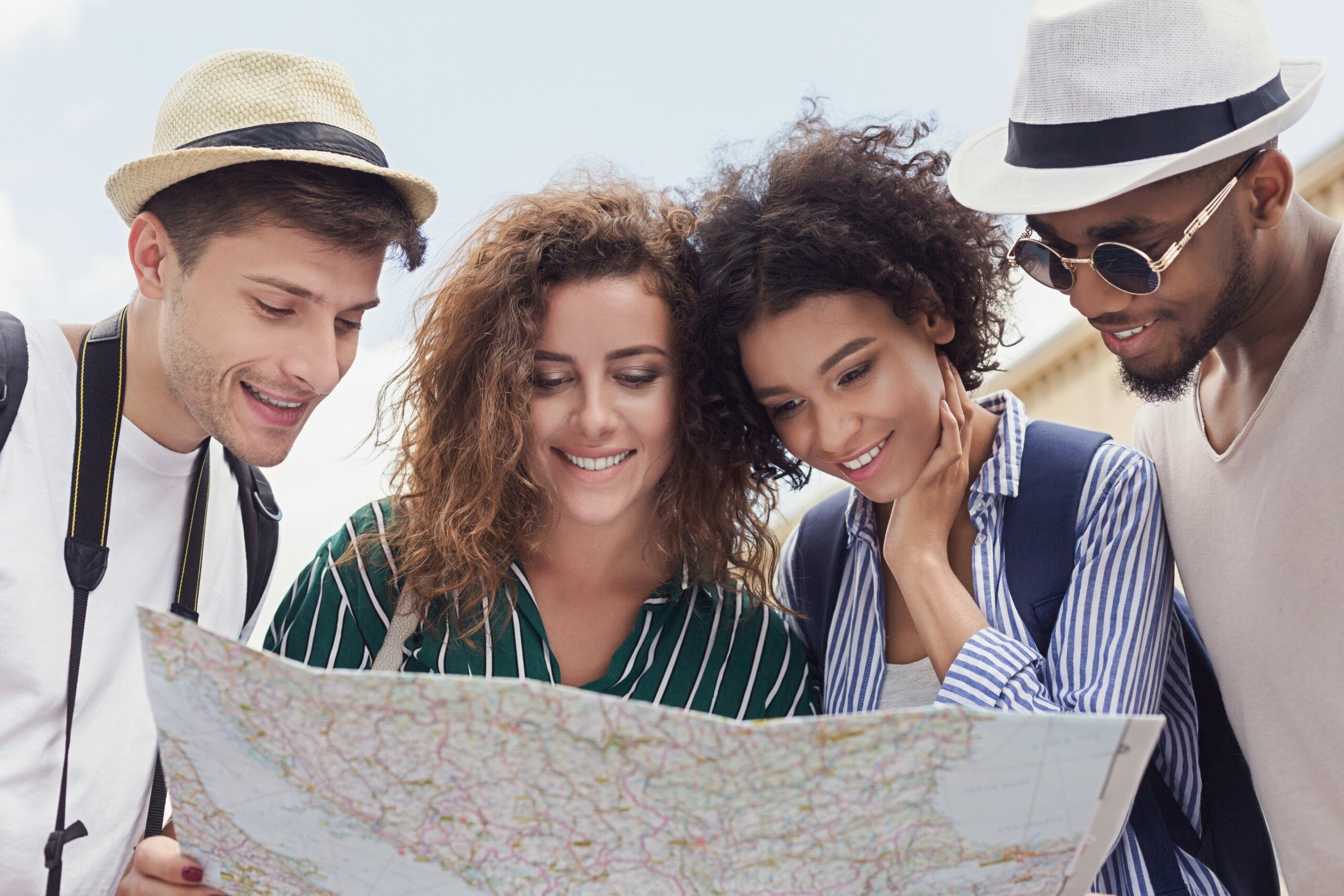 Happy travelers searching the location on city map
