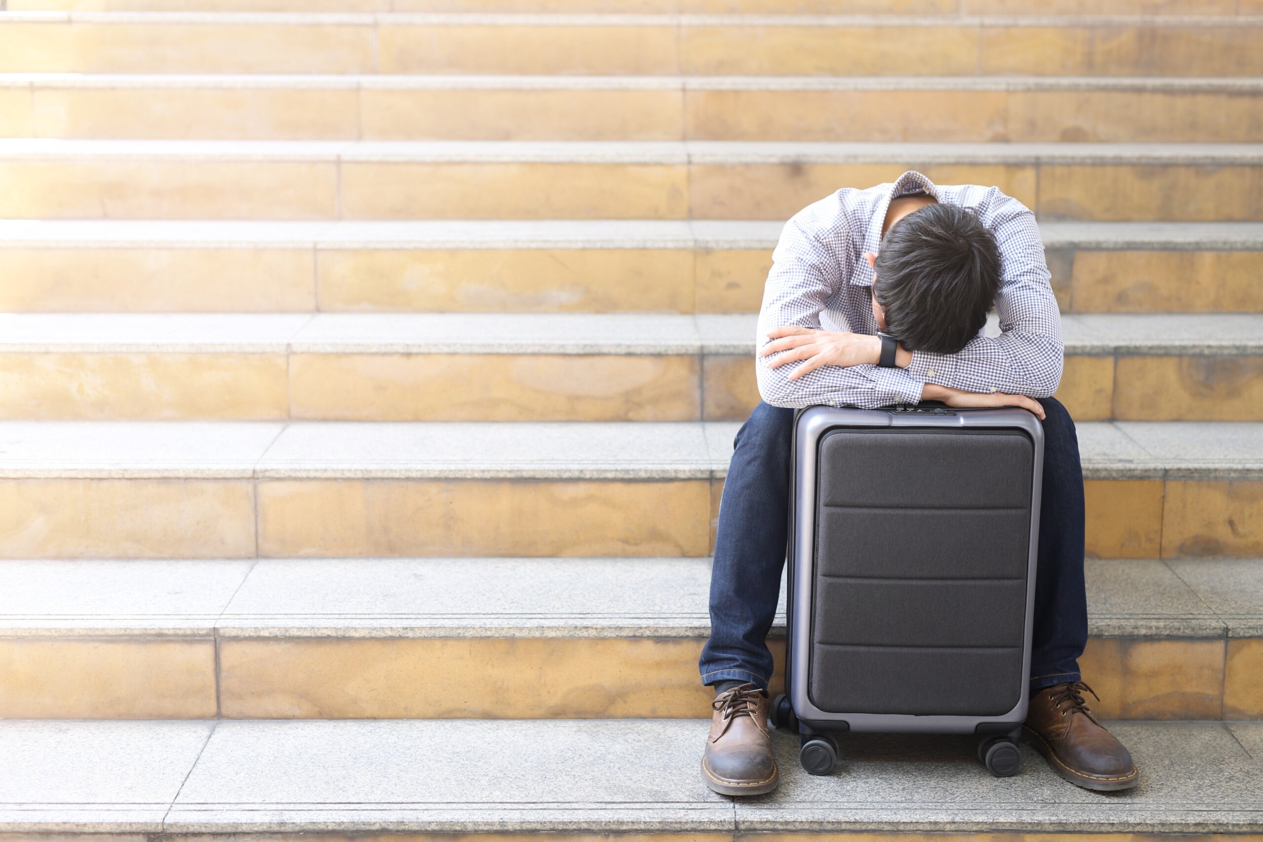 The young man was tired and stressed on the suitcase