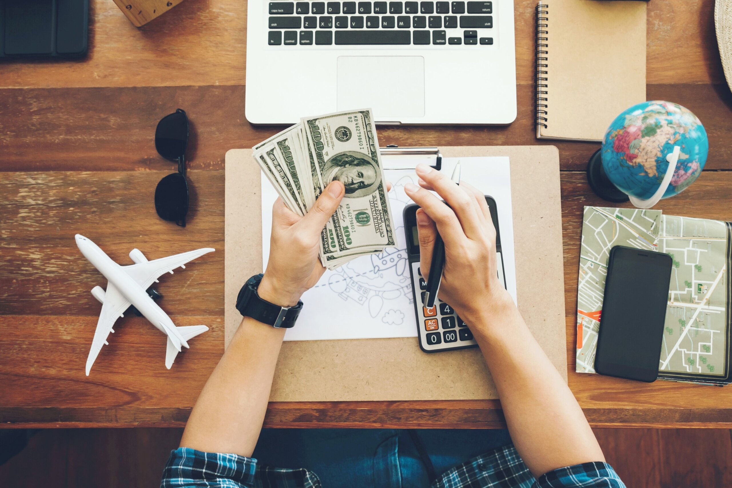 Top view tourist counting cash to spend during his luxury vacation, planning budget