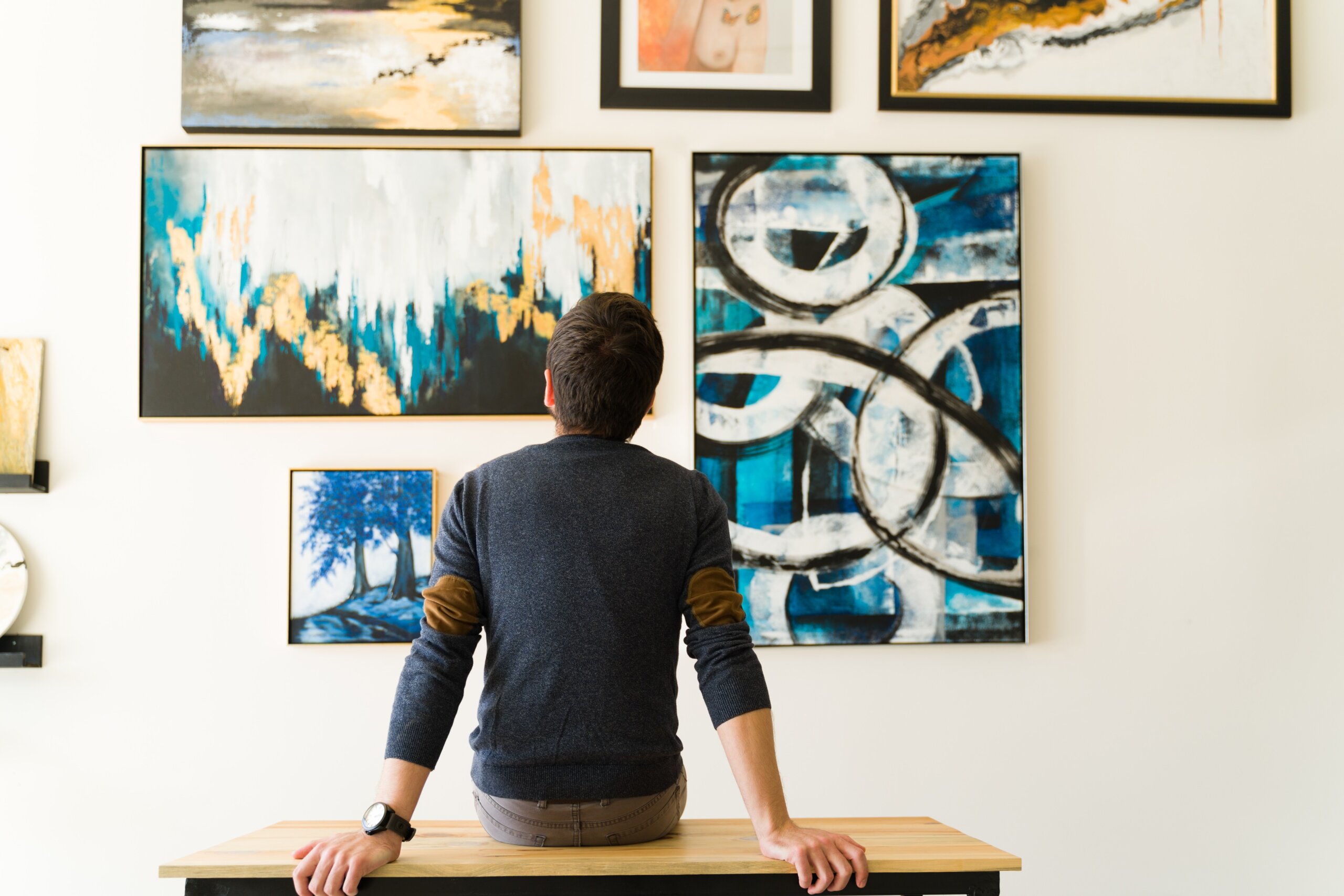 Rear view of a man in his 30s looking at an art exhibition
