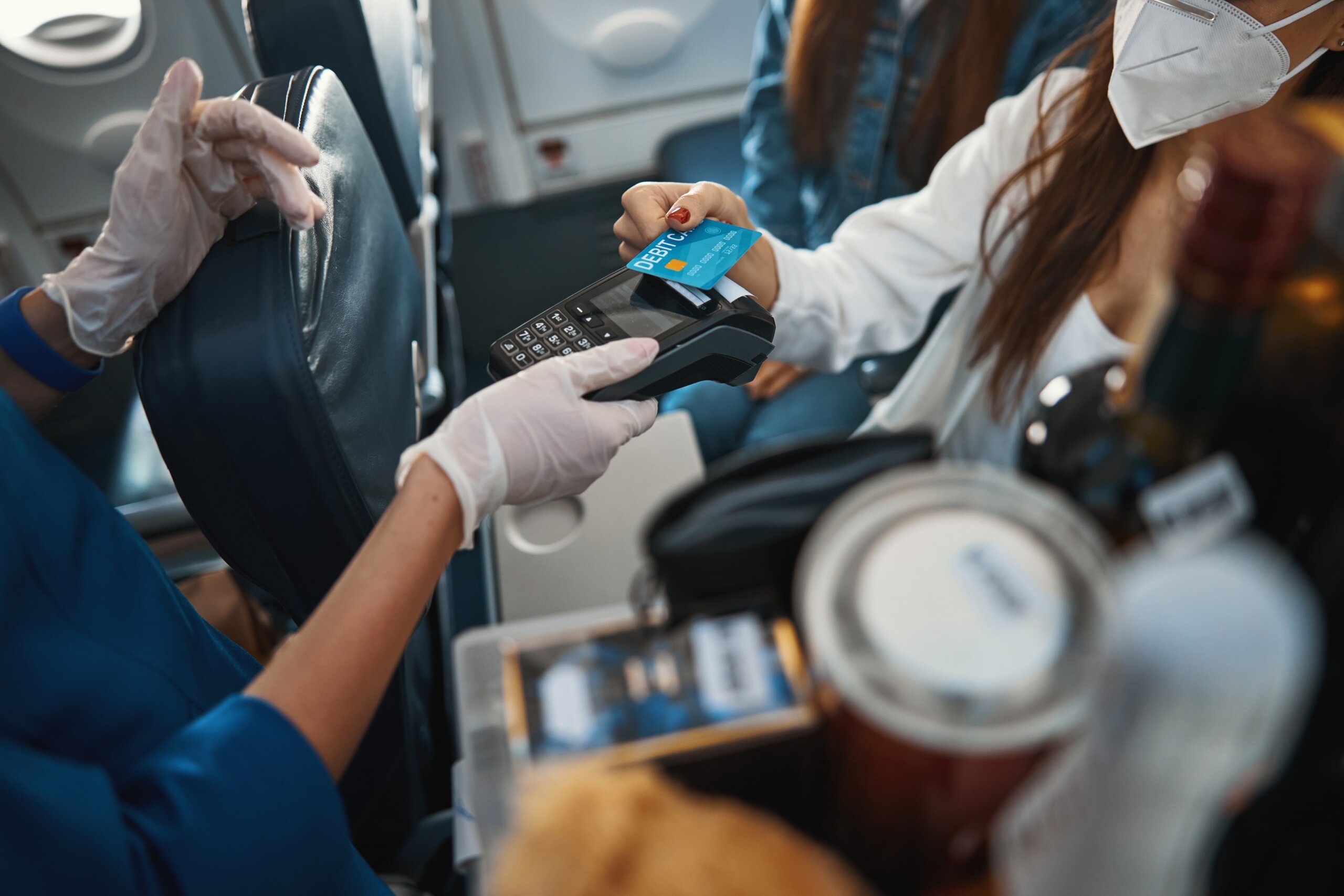 Woman paying for purchase with credit card on a plane
