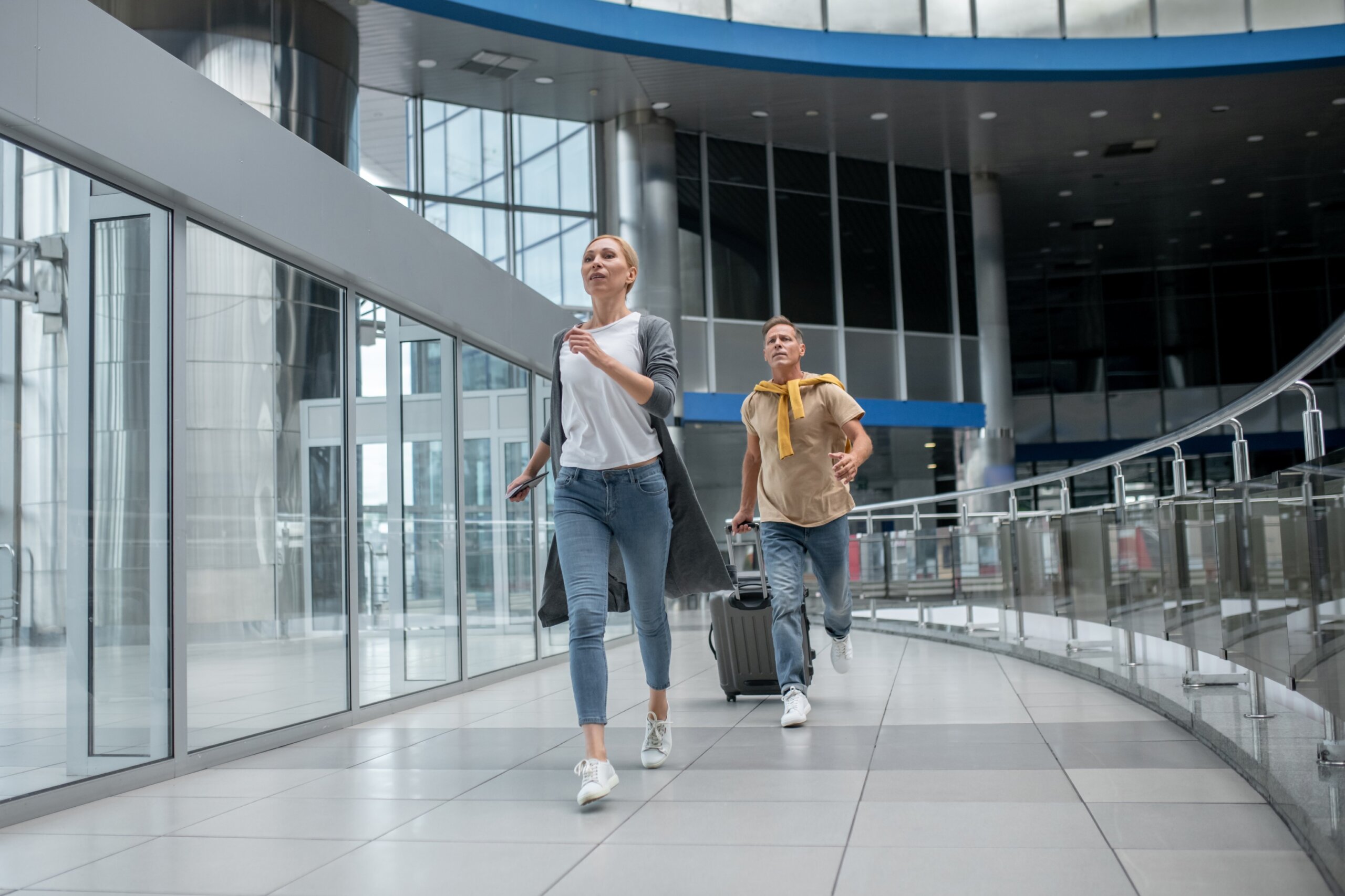 Two agitated passengers rushing through the airport terminal
