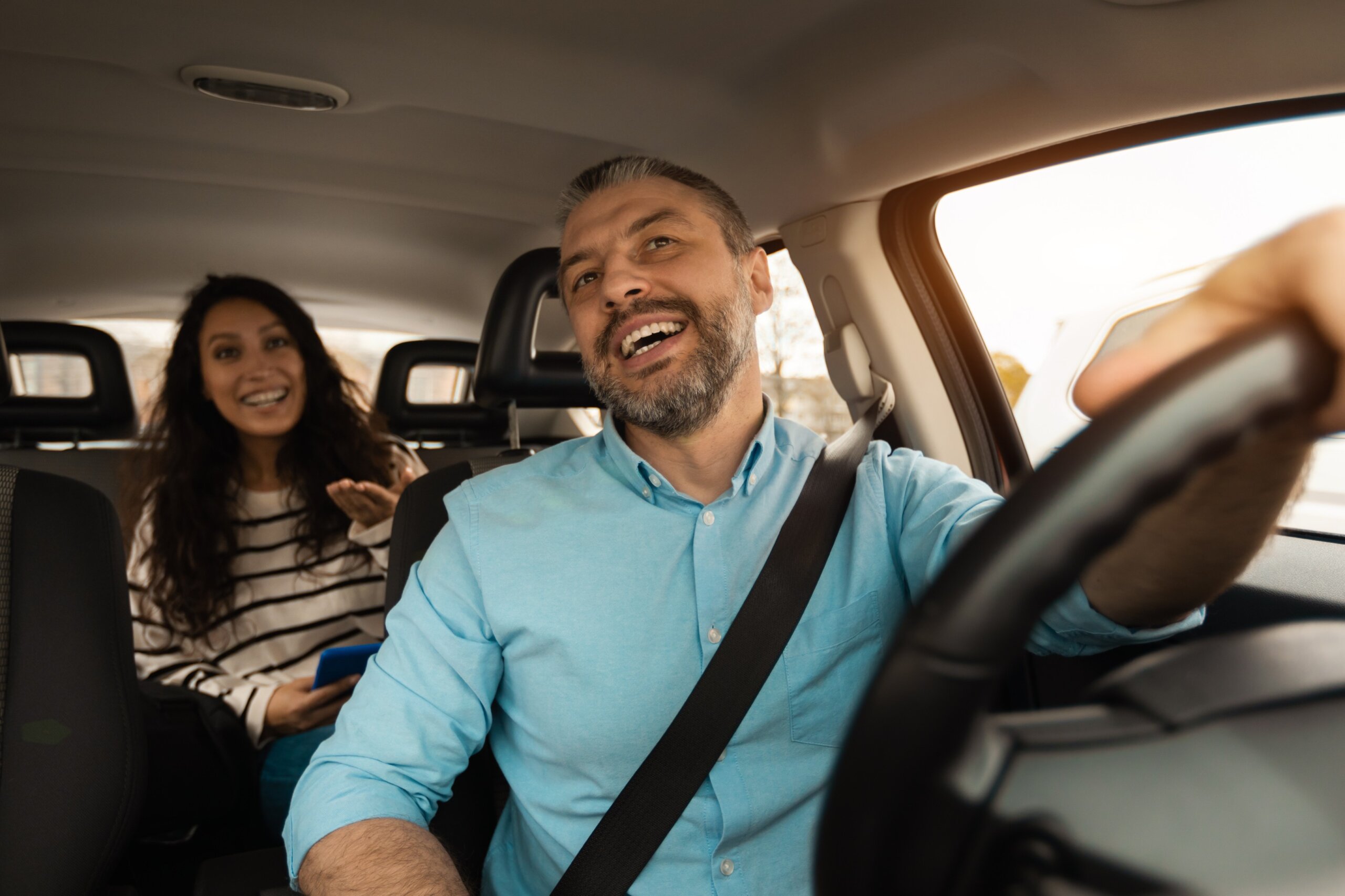 Portrait of happy male driver riding car with passenger
