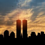 Silhouette of Twin Towers at sunset with birds flying above, symbolizing 9/11 remembrance