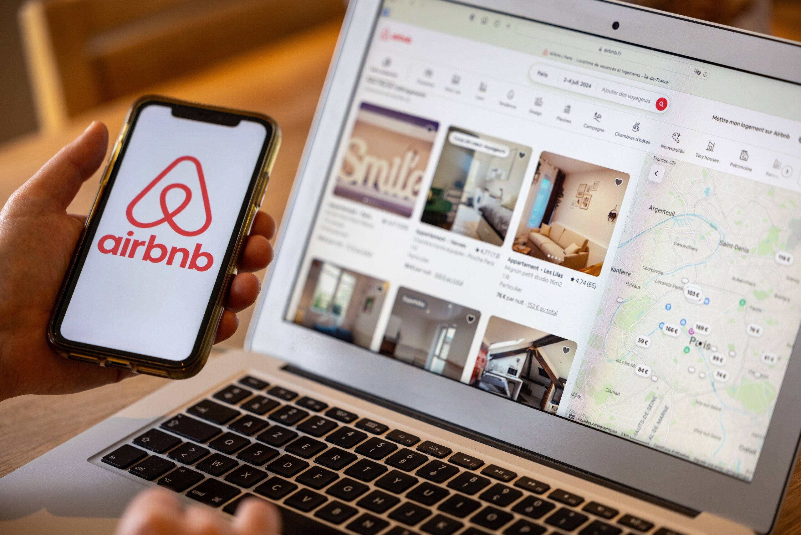 Female hand holding smartphone with Airbnb application. Airbnb is an online marketplace and hospitality service, enabling people rent short-term lodging