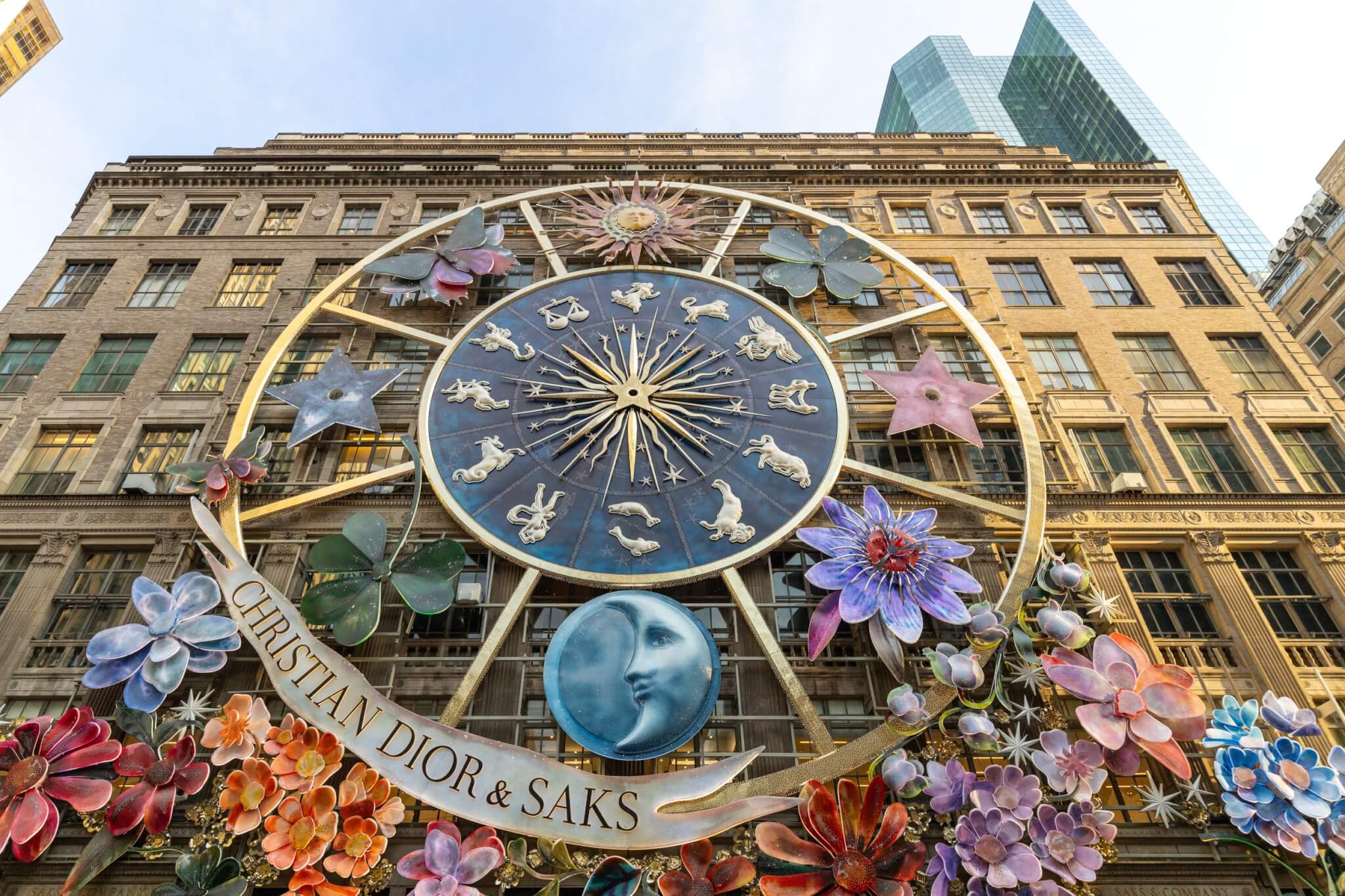 Christian Dior & Saks storefront on Fifth Avenue New York with zodiac display and flowers