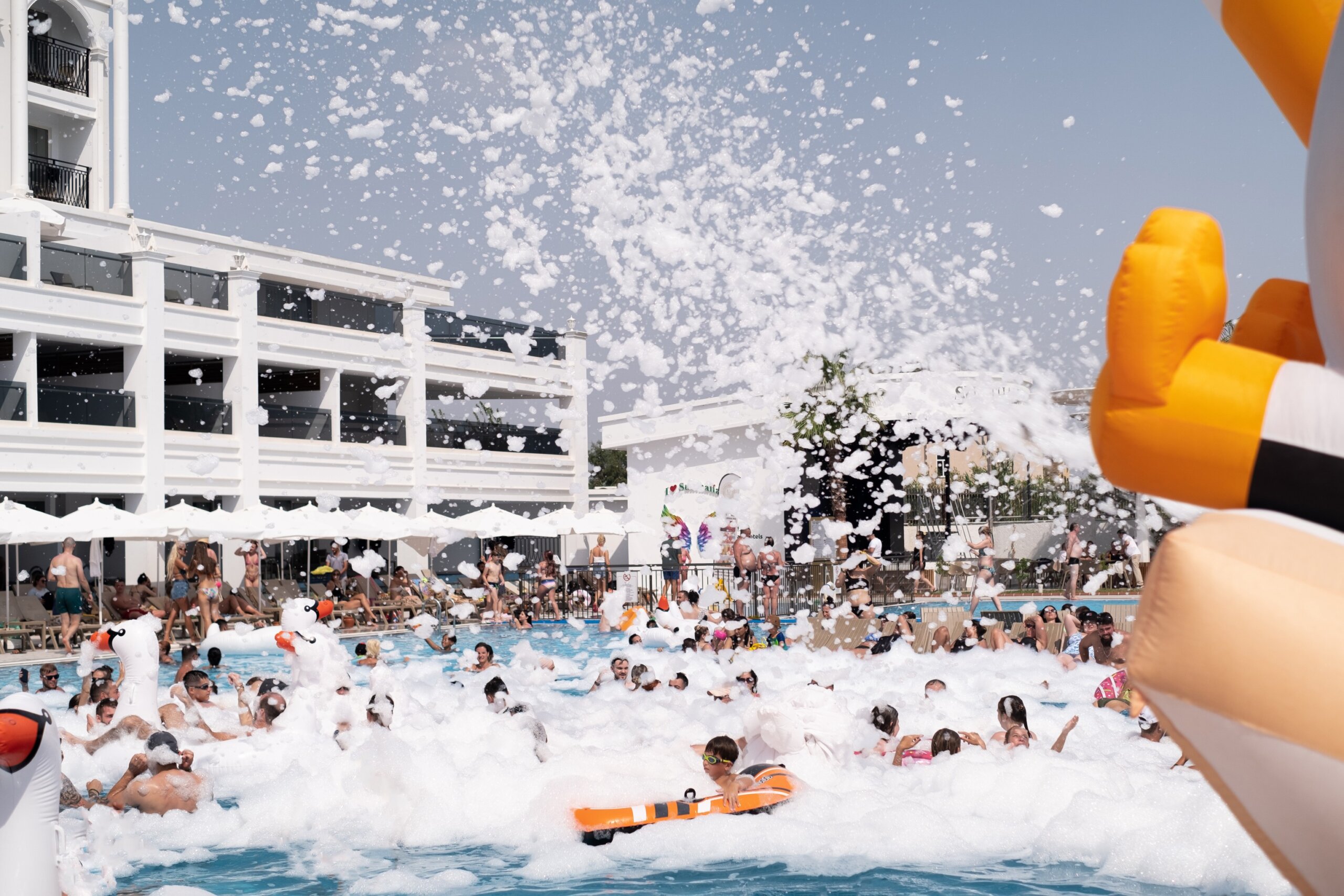 Foam party at the pool: epitome of resort fun. Ideal for hotel resorts, entertainment complexes, party supplies, cosmetics, and bathing essentials.