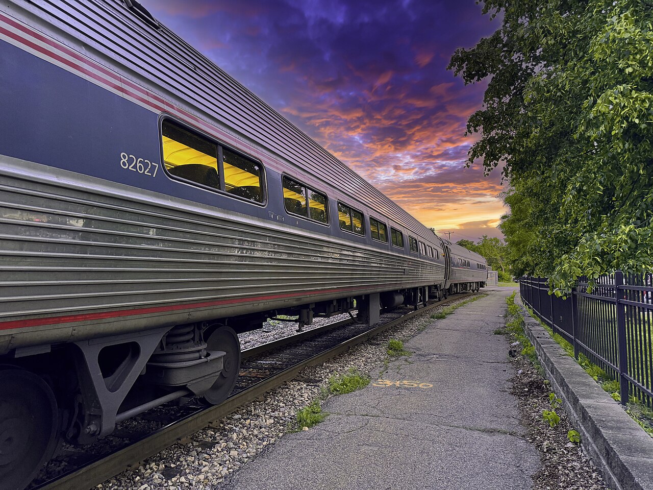 Amtrak Vermonter train at Essex Junction Station in Vermont during sunset, showcasing scenic fall foliage travel through New England.