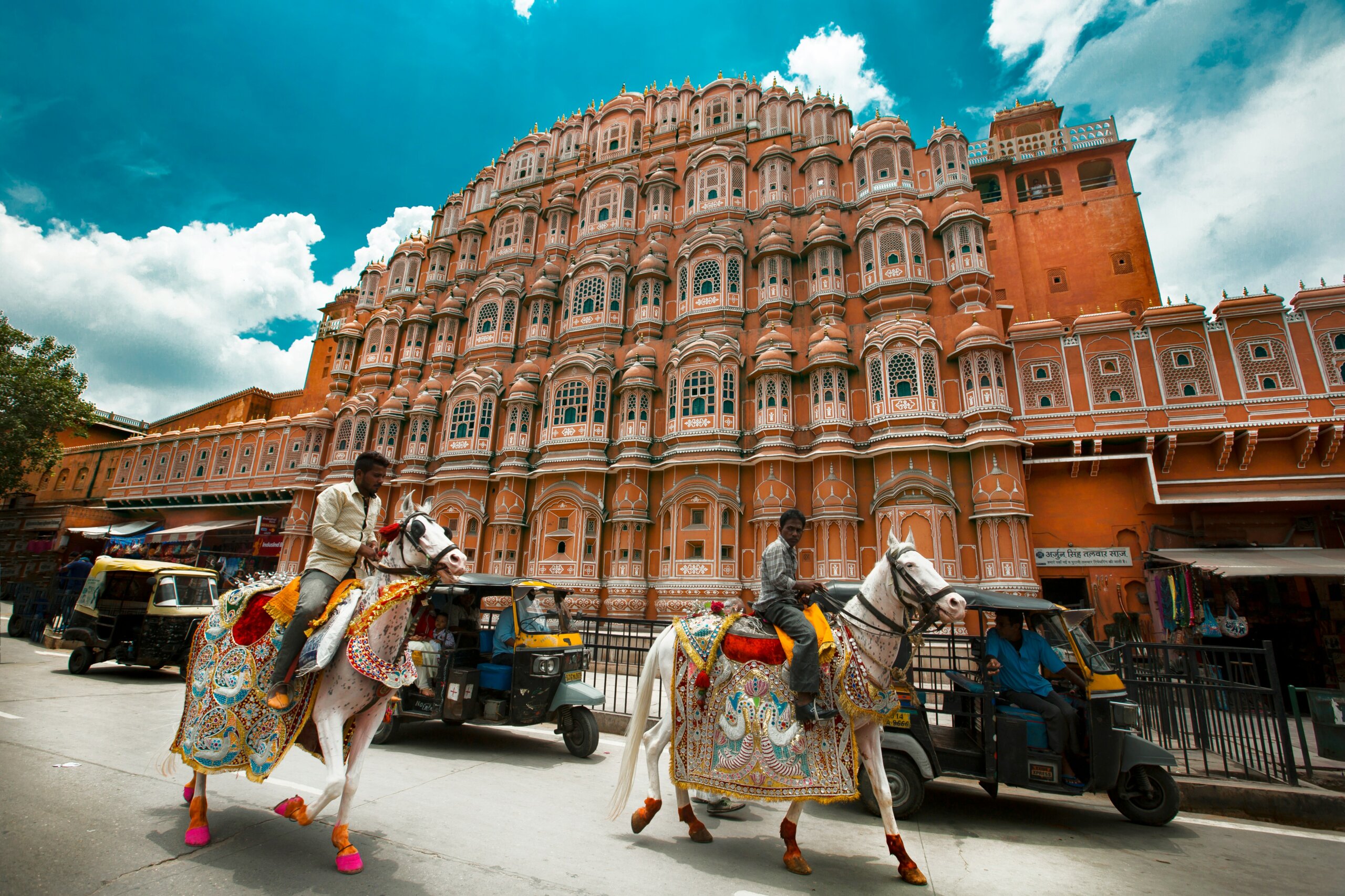 Hawa Mahal in Jaipur, Rajasthan with decorated horses in front — a historic palace and one of the must-visit forts and palaces in India.