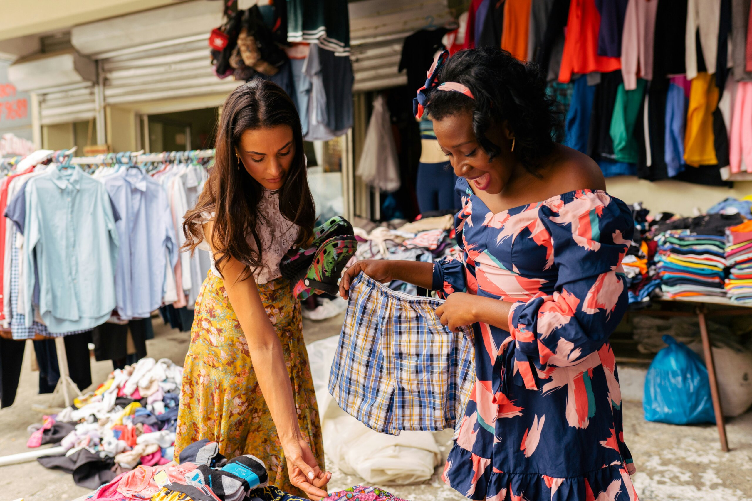 Two women shopping at an outdoor market — showing why saying “I can find this for a better price online” can be insulting to local vendors abroad.