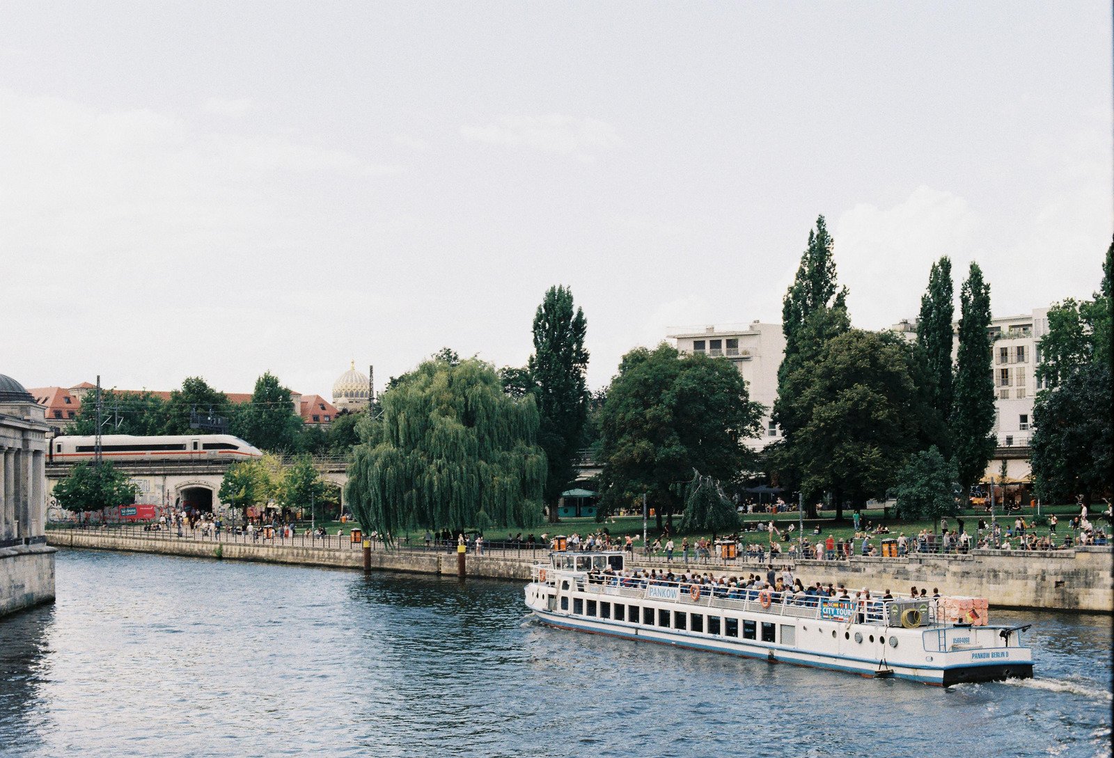 European river cruise ship docked in a historic city center, steps away from landmarks and bustling crowds.