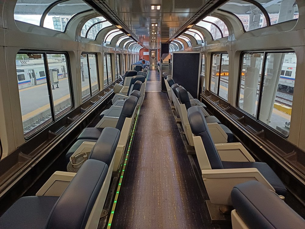 Amtrak California Zephyr Dome Car interior with panoramic windows and comfortable seating, offering scenic views of mountains, rivers, and fall foliage along the cross-country route.