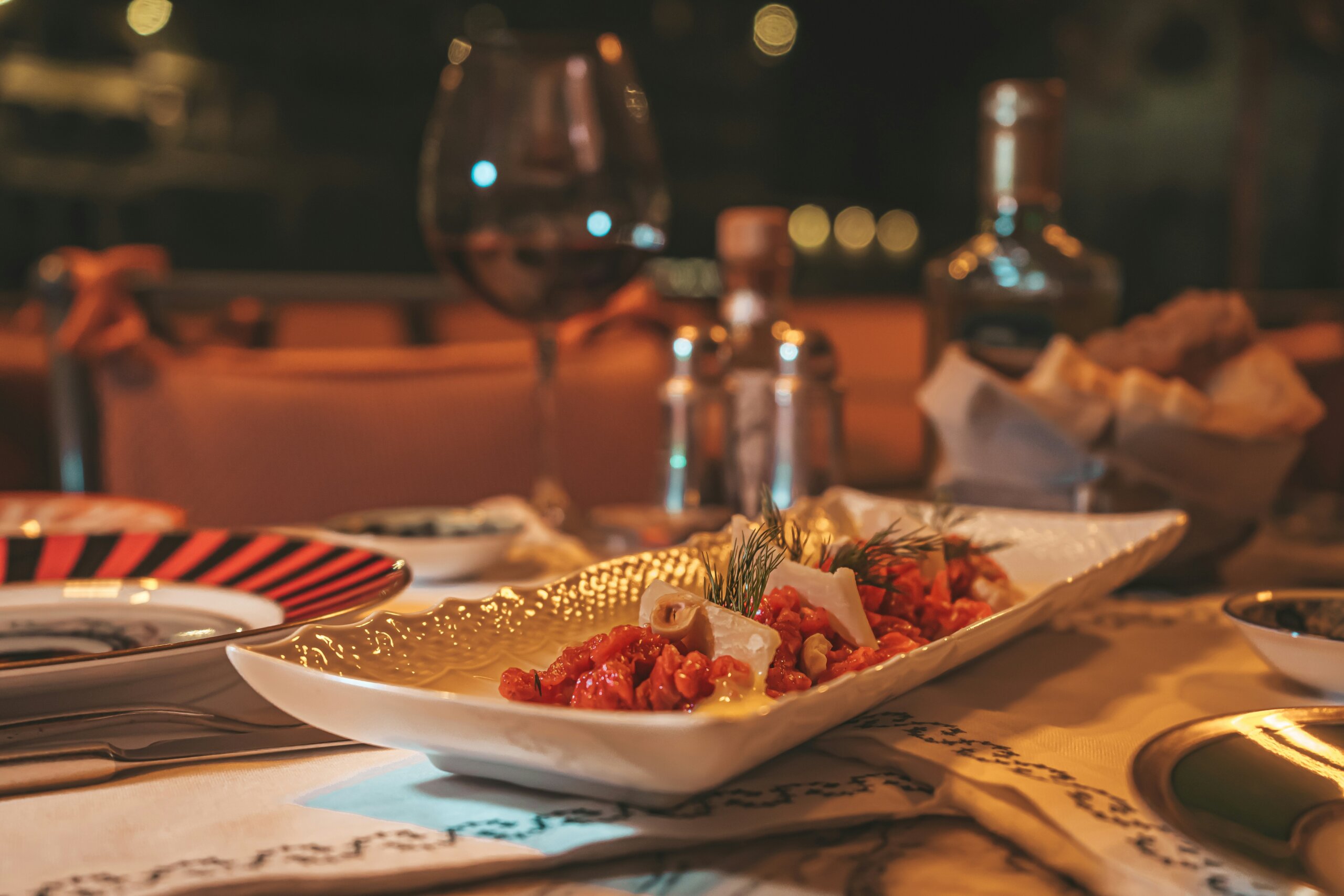 Traditional Italian dinner table with wine, bread, and antipasti dishes symbolizing slow dining culture.