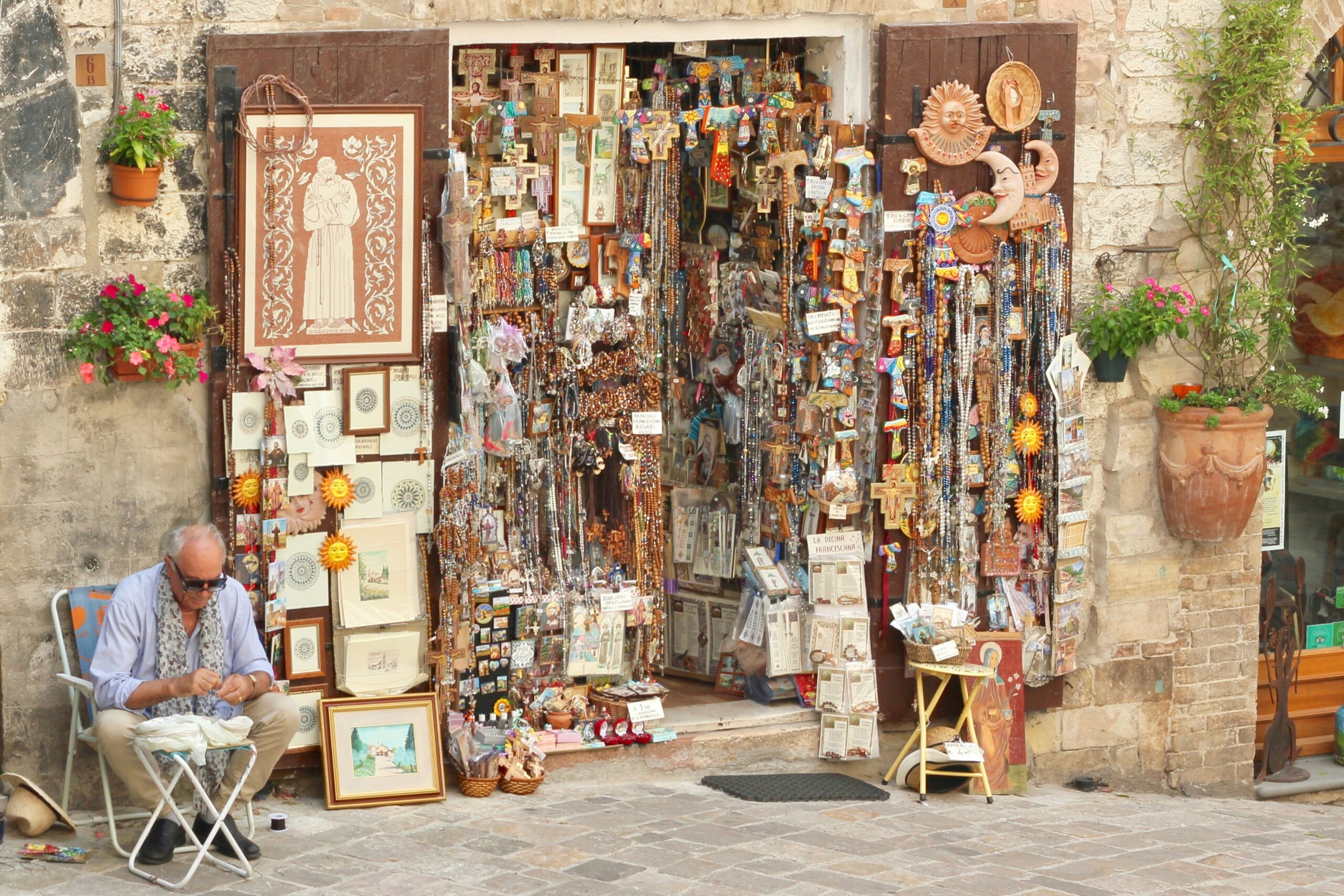 Italian souvenir shop with handcrafted art, jewelry, and trinkets, encouraging travelers to support local artisans when shopping.