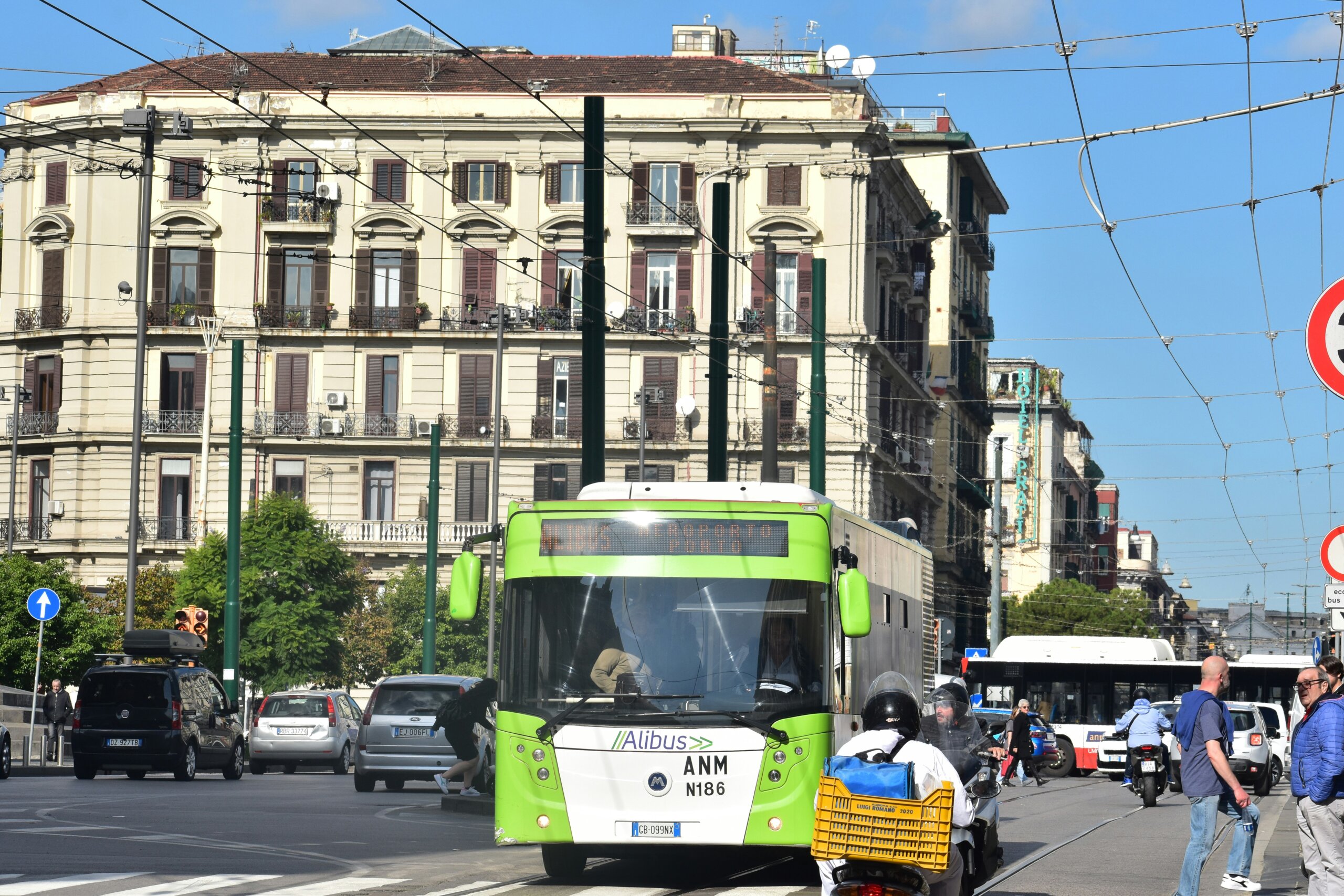 Busy street in Naples with public bus, cars, and people showing Italian city life.