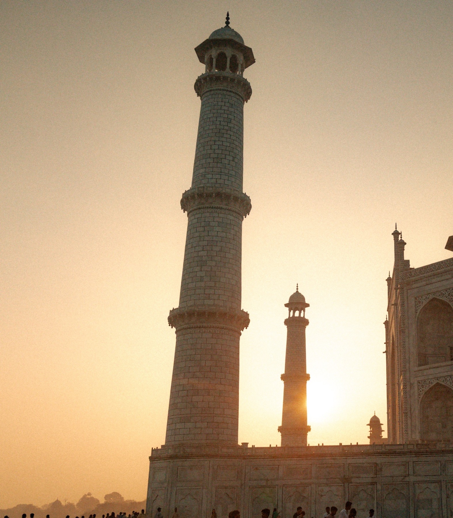 The sun coming up behind the minarets of the Taj Mahal. 
