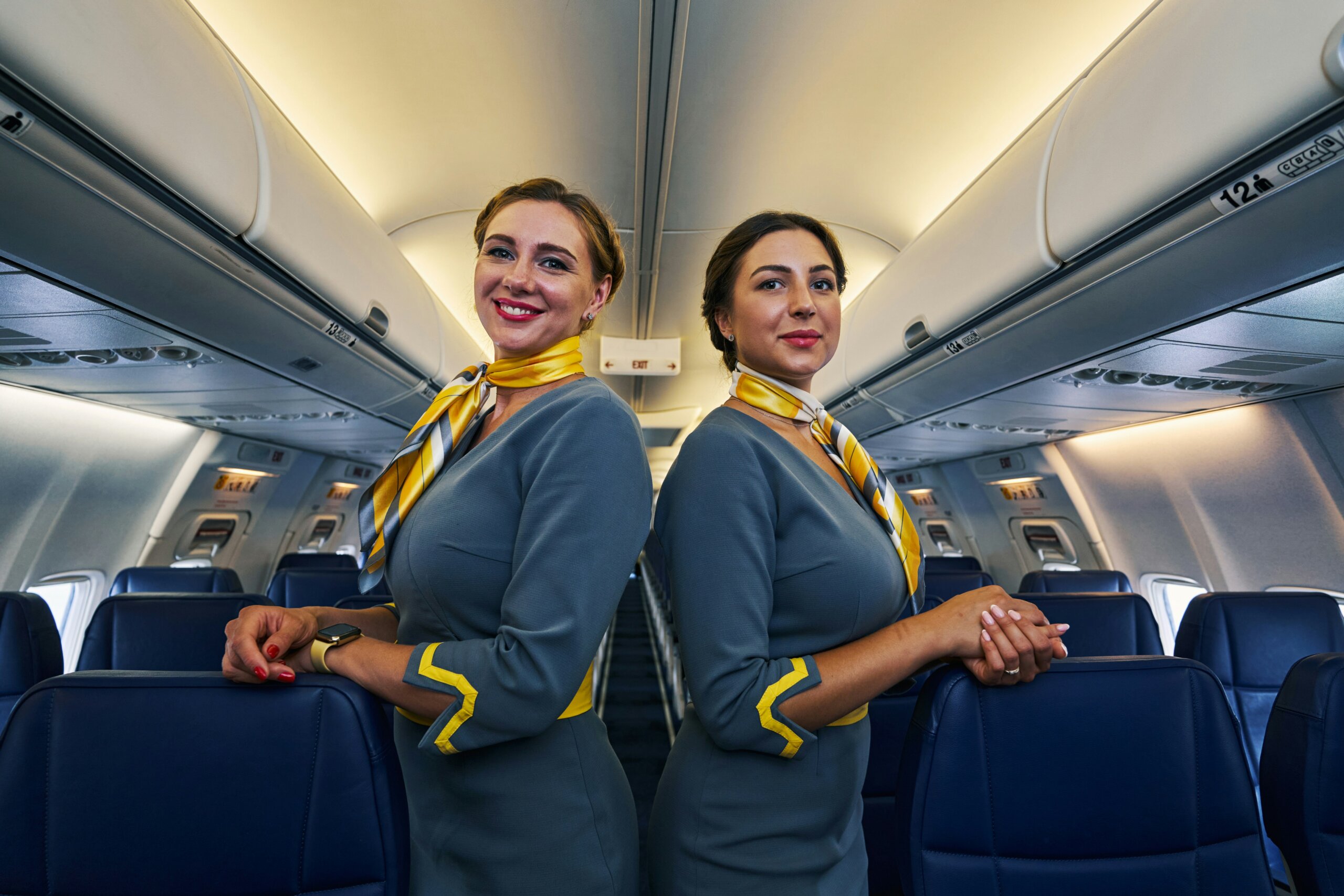 Two airline flight attendants in uniform inside a plane cabin, symbolizing airlines with the best and worst flight crews.