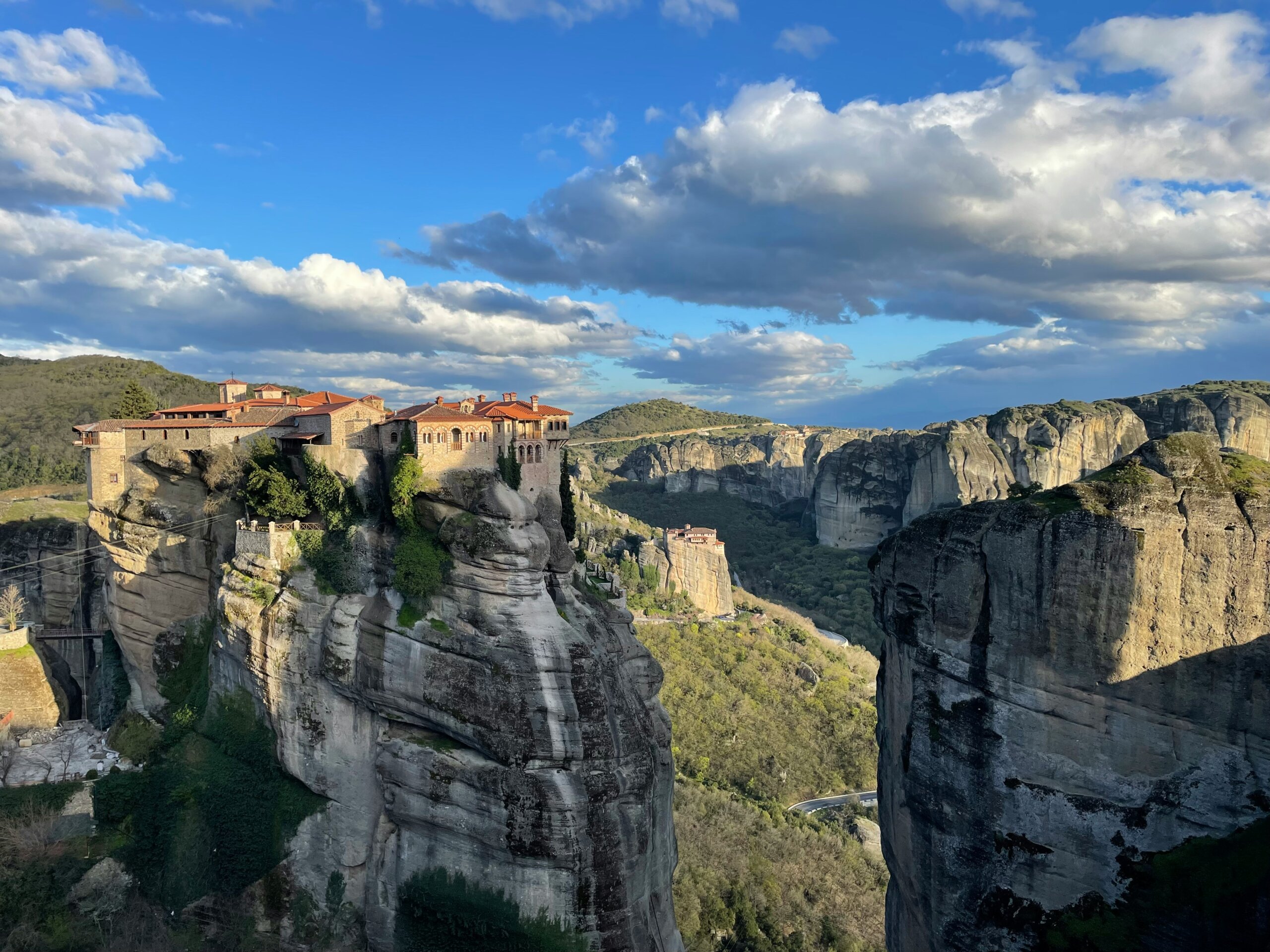 Traveler overlooking Meteora Monasteries in Greece, a UNESCO World Heritage Site and one of Europe’s most sacred spaces.