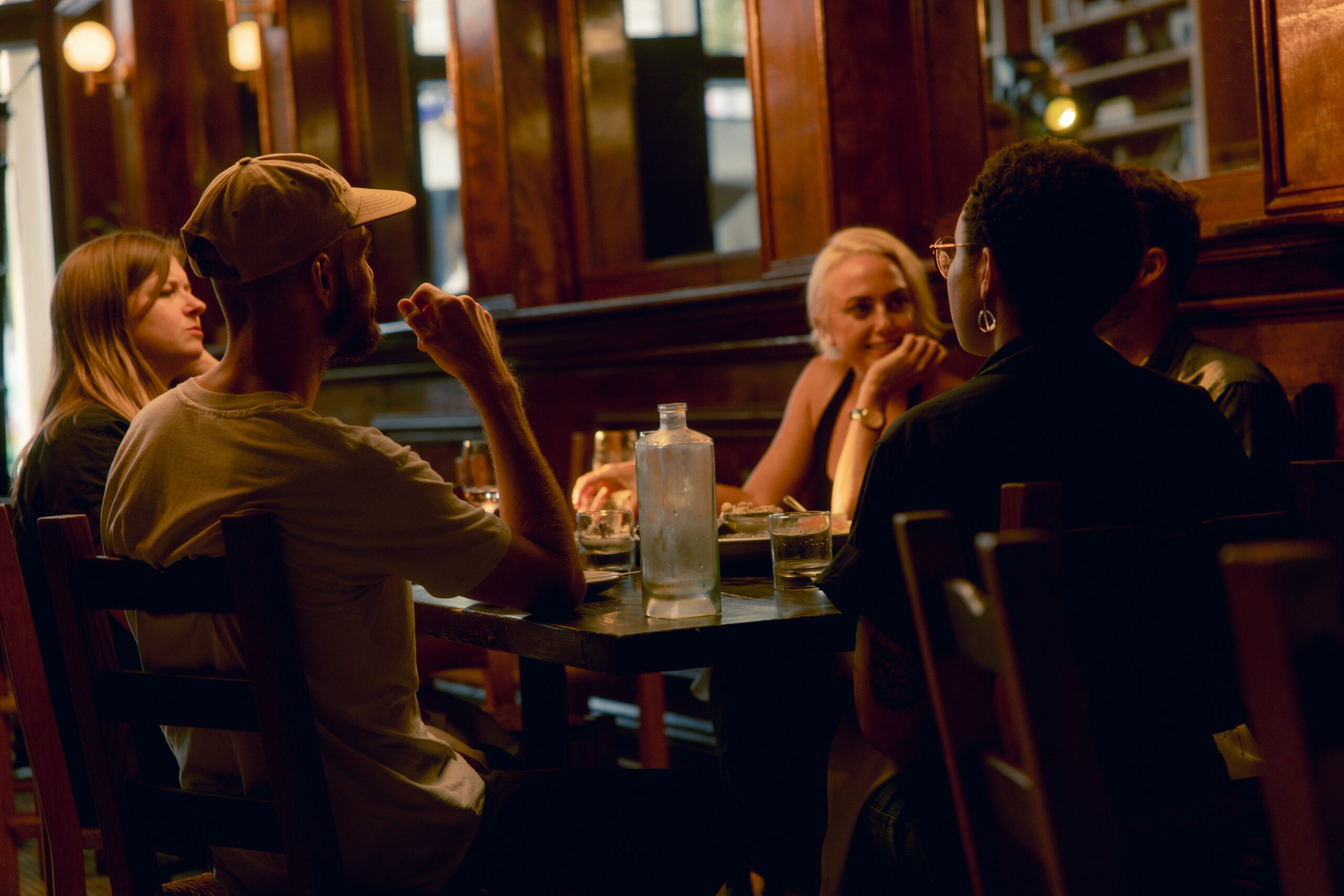 Group of people talking loudly at a restaurant — illustrating why loud political speech about home can make locals uncomfortable when traveling abroad.