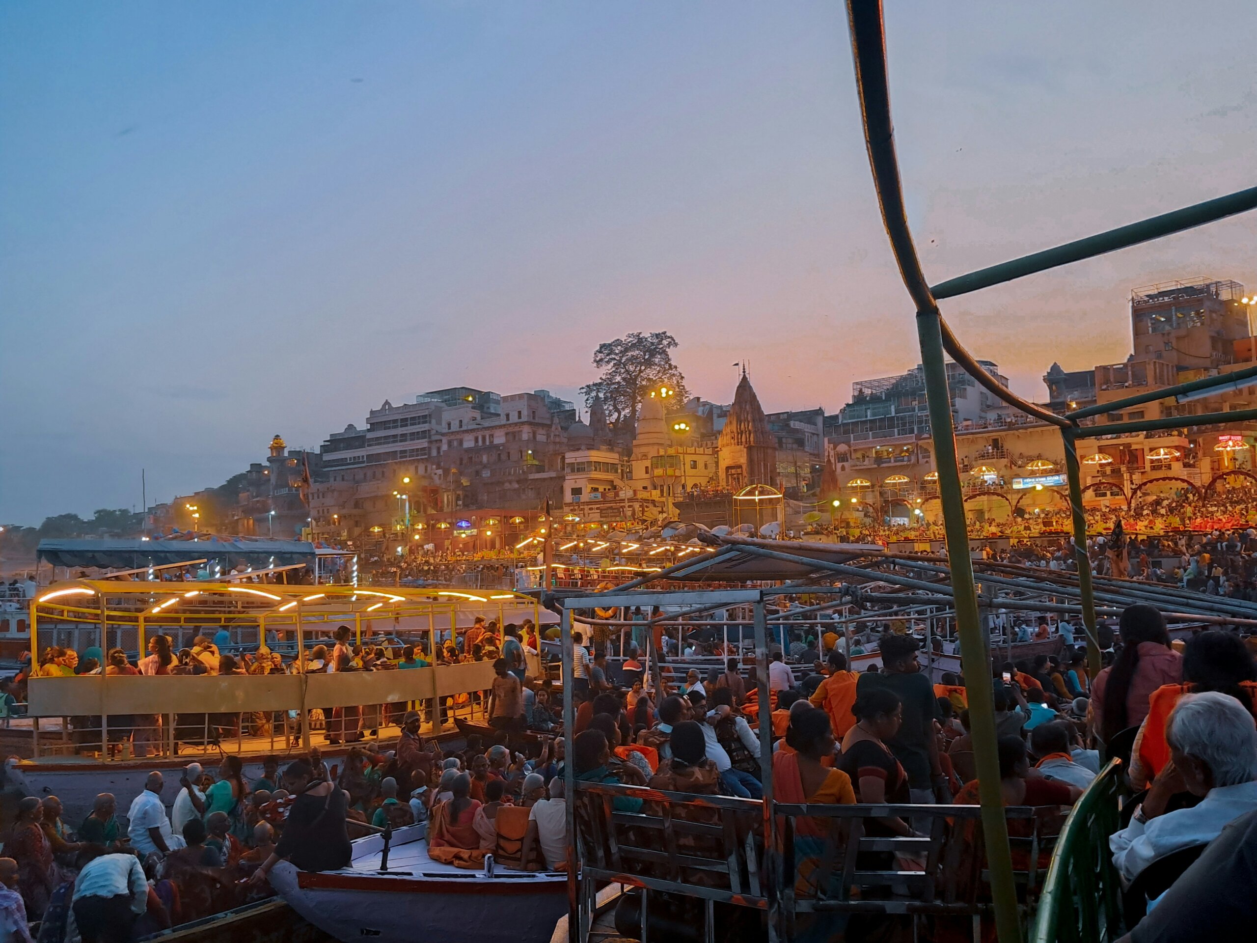 Crowds gathering at the ghats of Varanasi at sunrise — boats on the Ganges River with temples and rituals, a must-see experience when traveling in India.