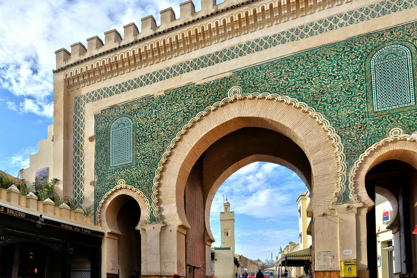 Ornate Bab Bou Jeloud gate in the old town of Fes, Morocco with intricate green and blue tilework.