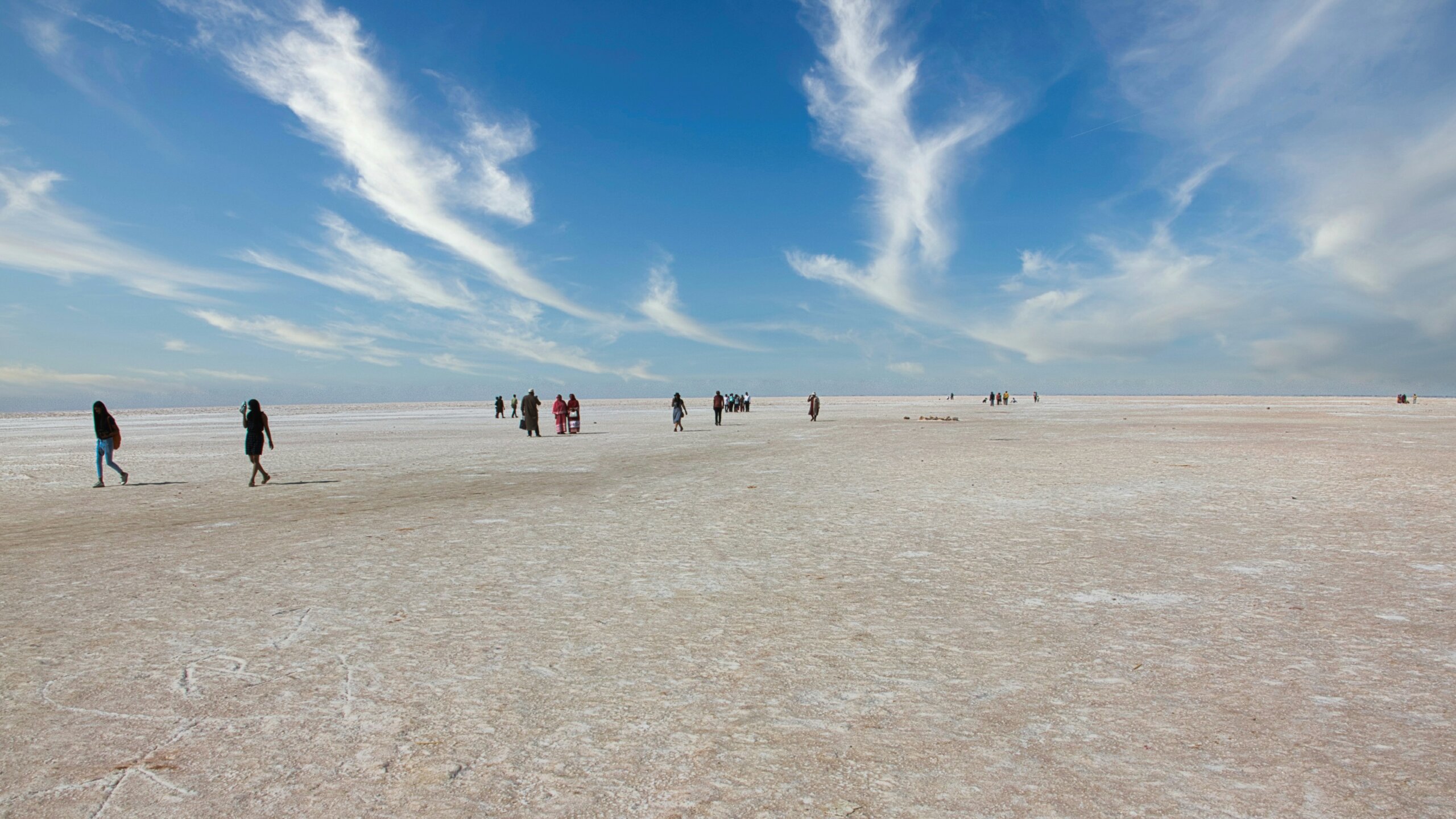 Travelers walking across the vast white salt desert of the Rann of Kutch in Gujarat — a unique natural wonder and cultural highlight of India.