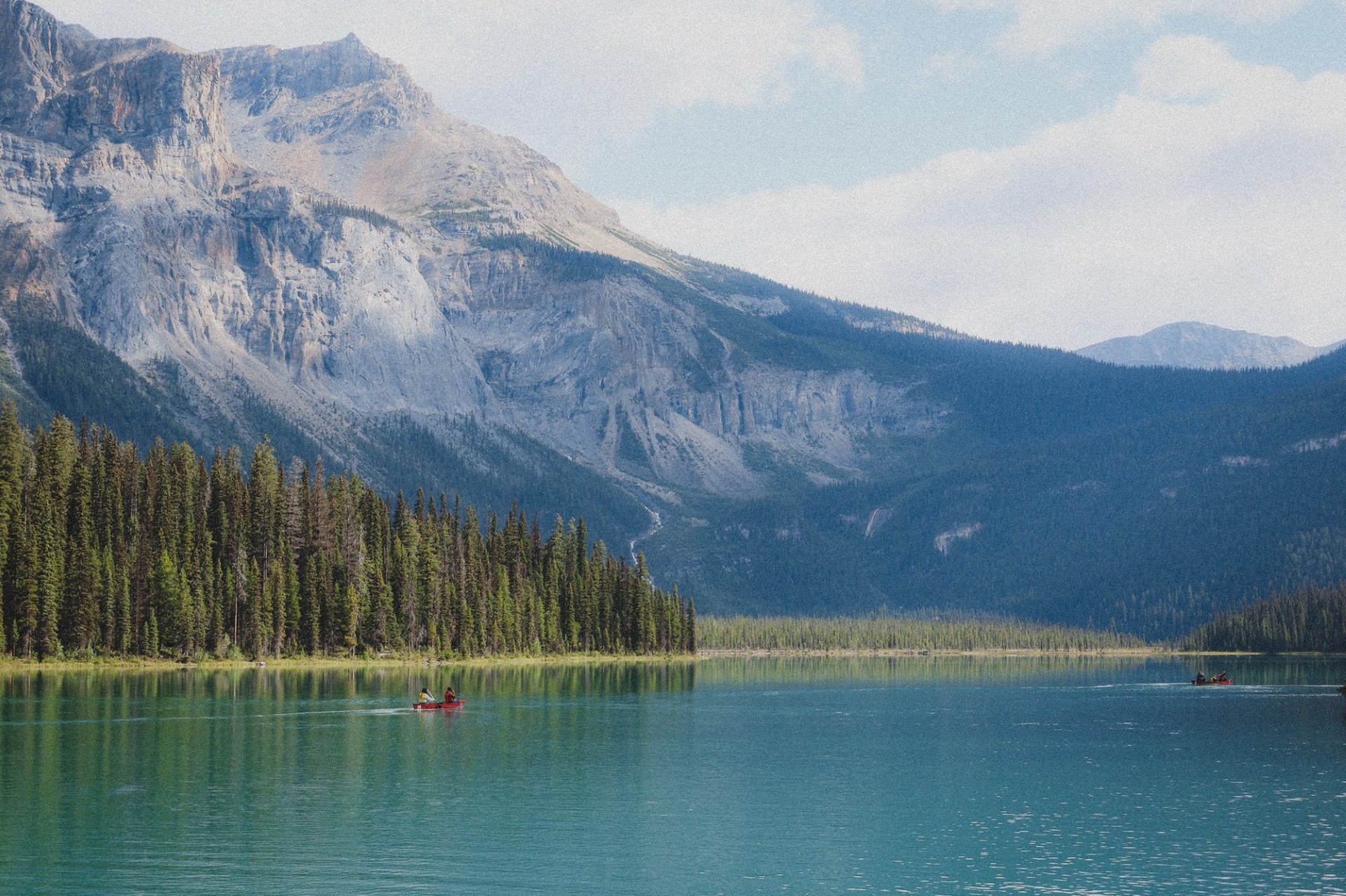 Canoe on turquoise Emerald Lake surrounded by mountains and forests in Yoho National Park, a popular day trip from Banff.